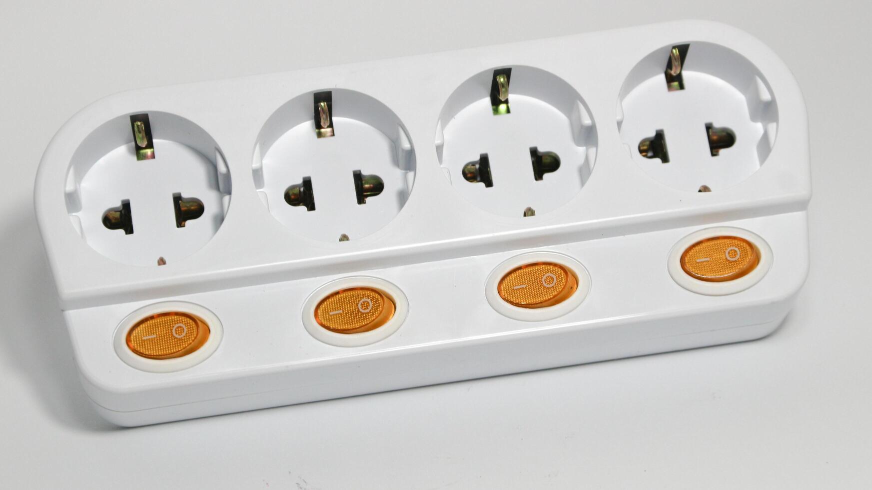 White power strip with four electrical outlets and orange switches photo
