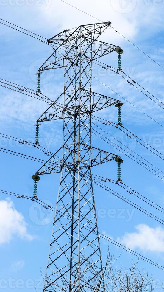 This is tall transmission line tower on clear blue sky background, photo