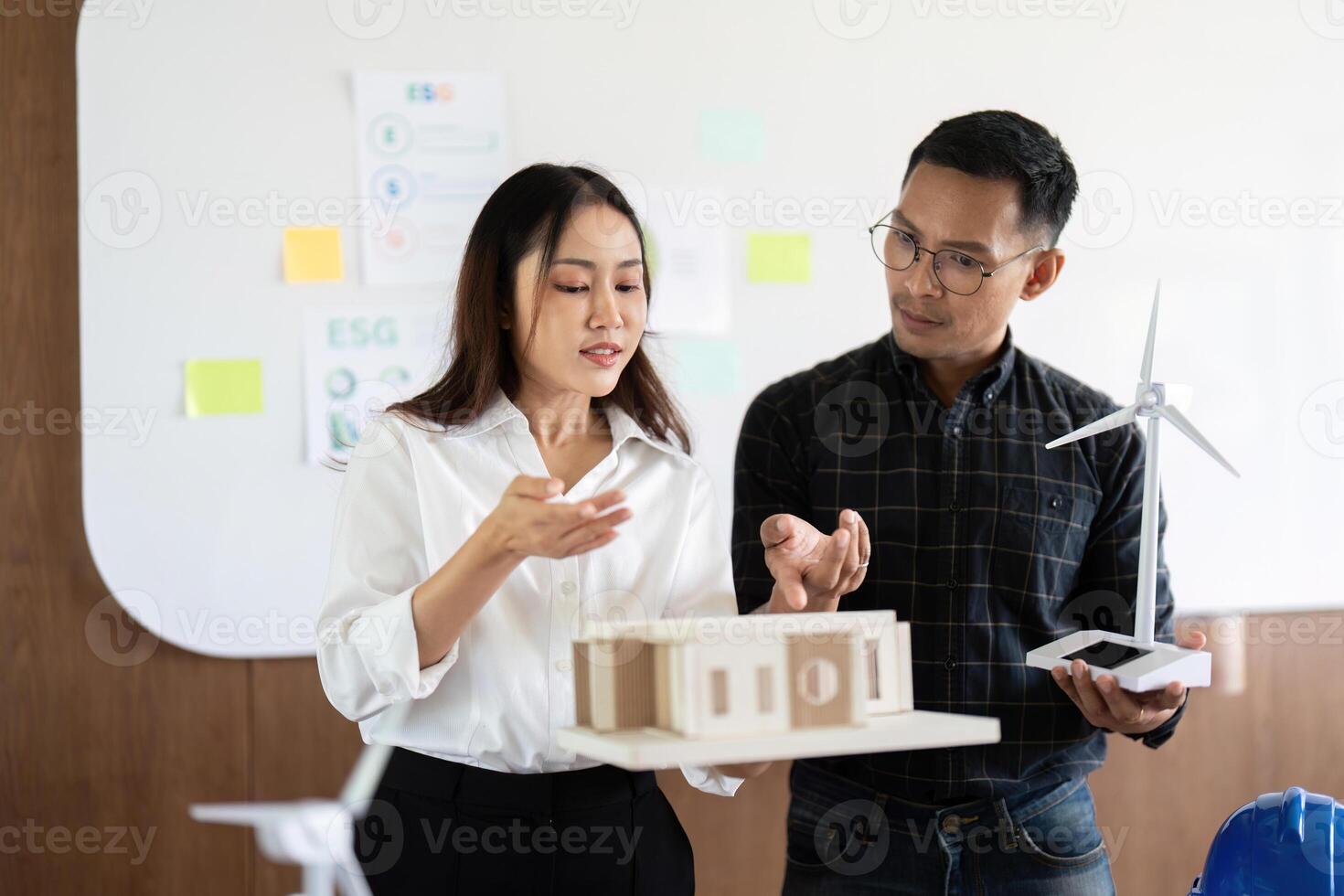 Sustainability and Engineering. Engineers presenting eco-friendly models in a collaborative workspace. photo
