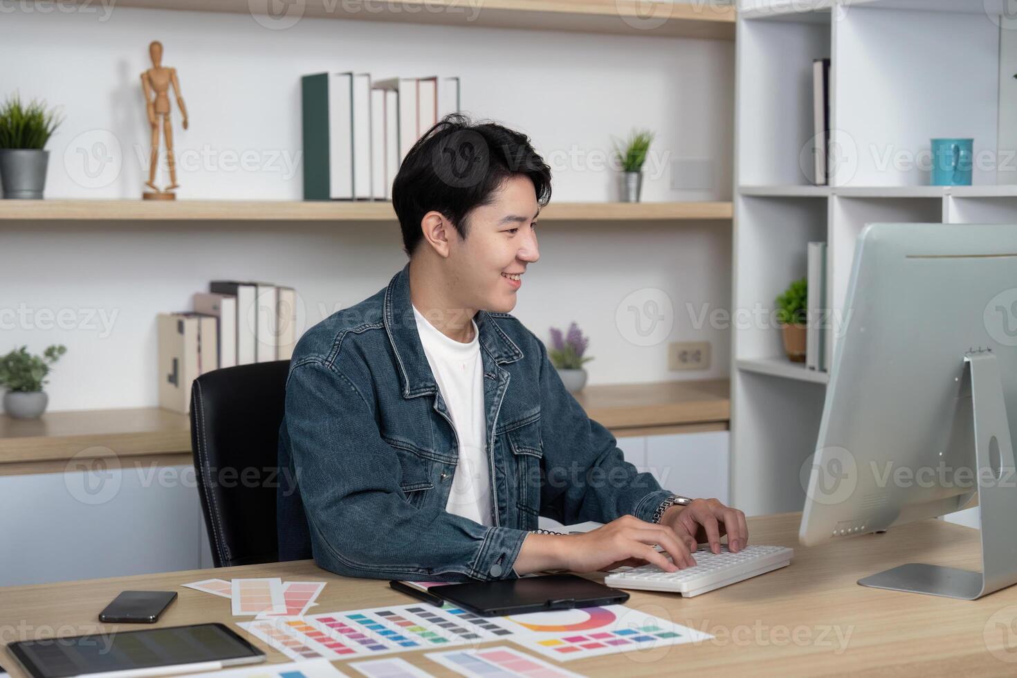 Modern Design. Young Professional Typing on Computer in Creative Workspace photo