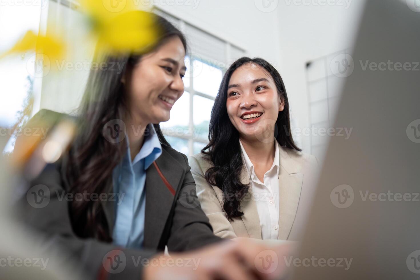 Engaging Discussion. Two businesswomen sharing insights while working on a laptop. photo