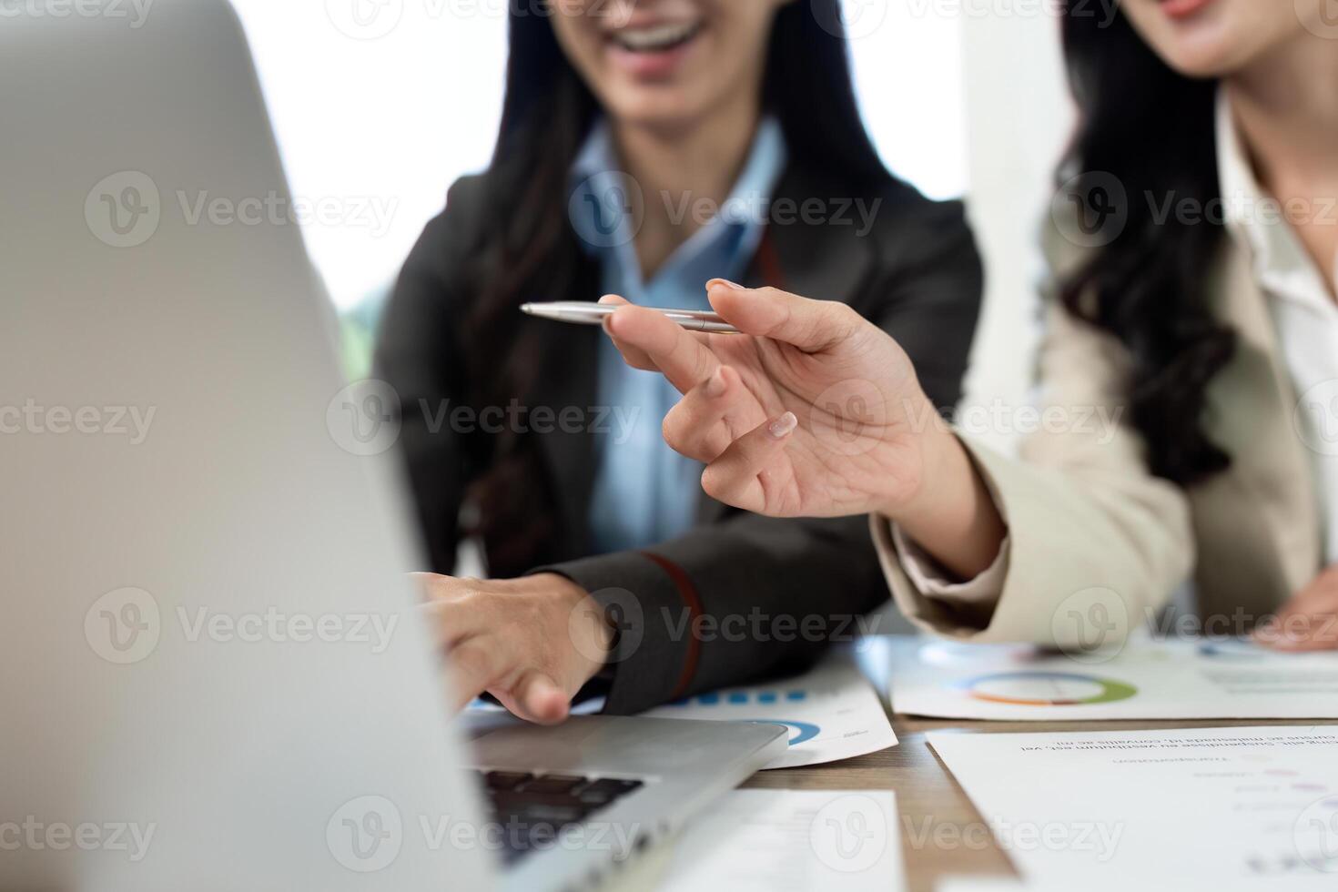 Collaborative Work Environment. Professionals discussing data on a laptop. photo