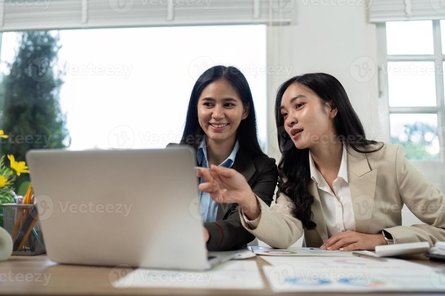 Collaboration and Teamwork. Two businesswomen discussing strategies on a laptop. photo