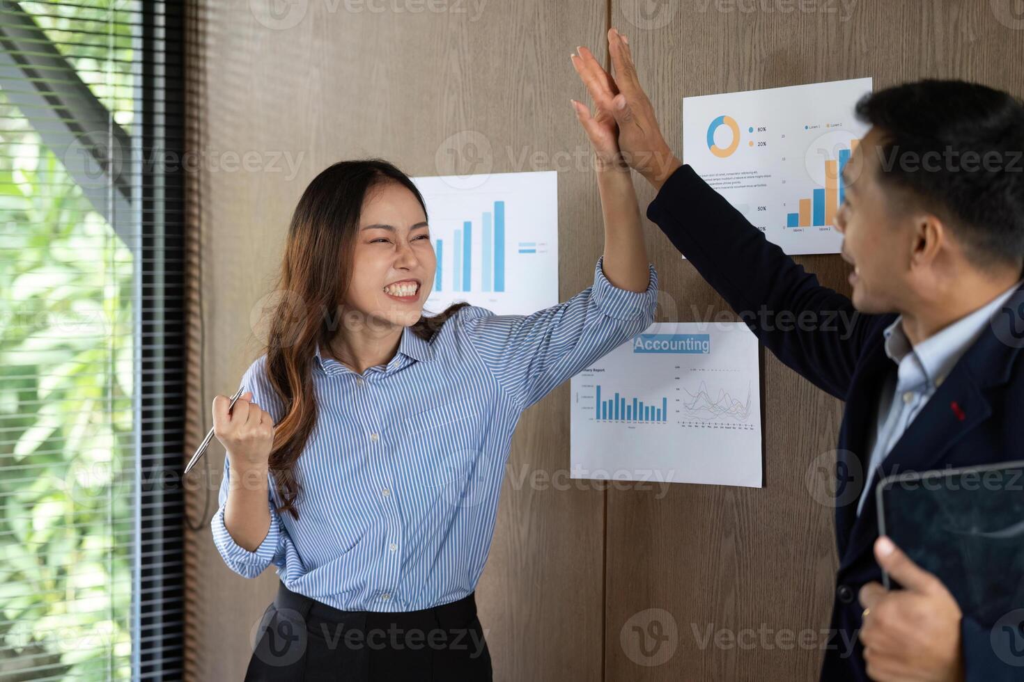 Dynamic Team Interaction. Colleagues celebrating success with high-fives in an office. photo