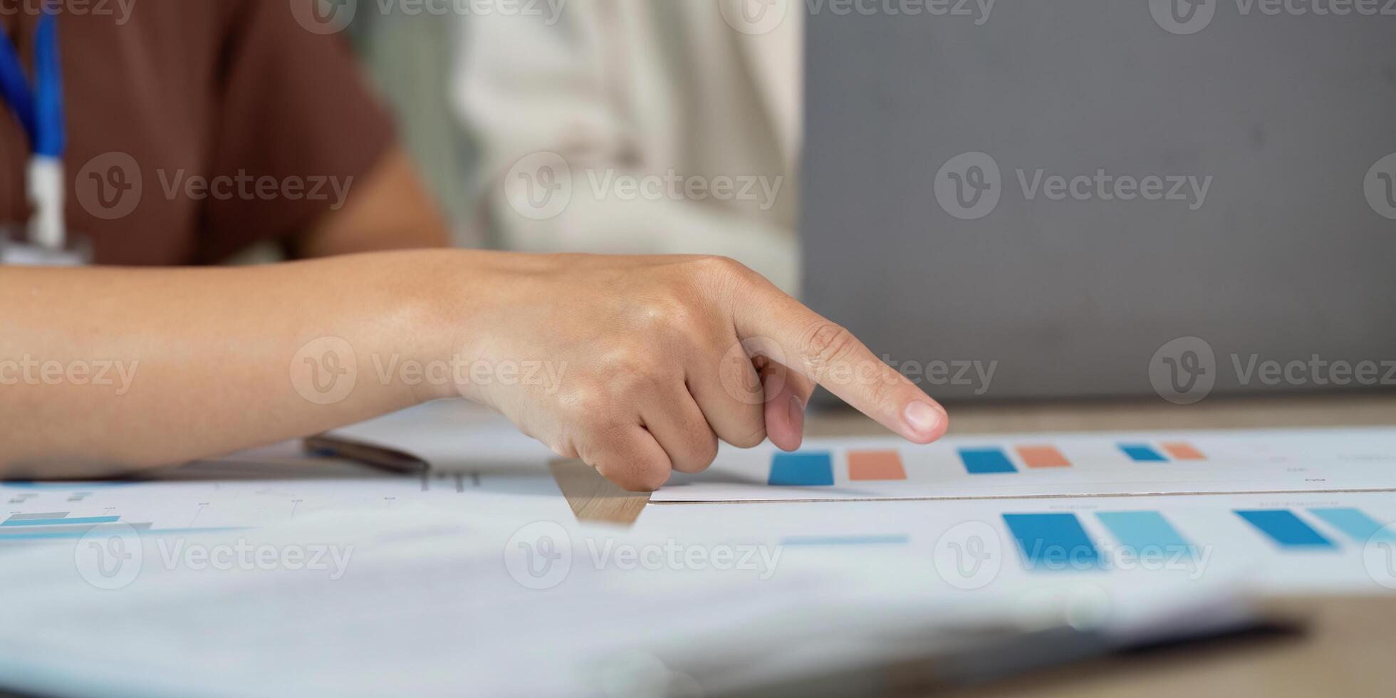 Data Analysis and Strategy. Professional pointing at financial graphs during a team meeting. photo