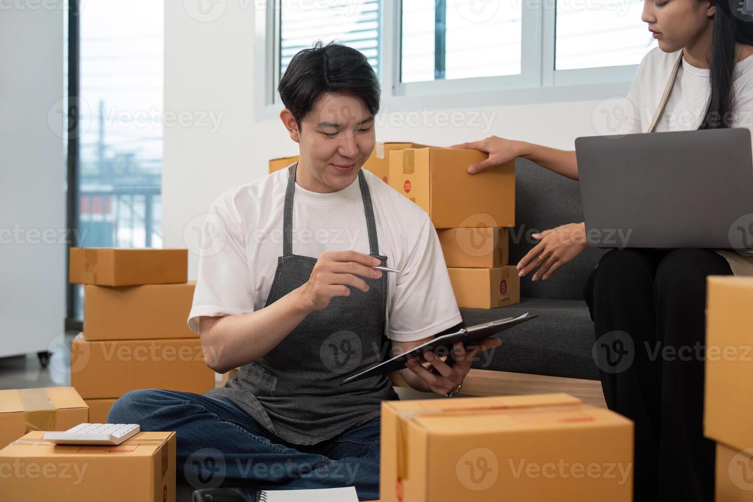 Couple analyzing logistics while managing packages in a shared workspace. photo