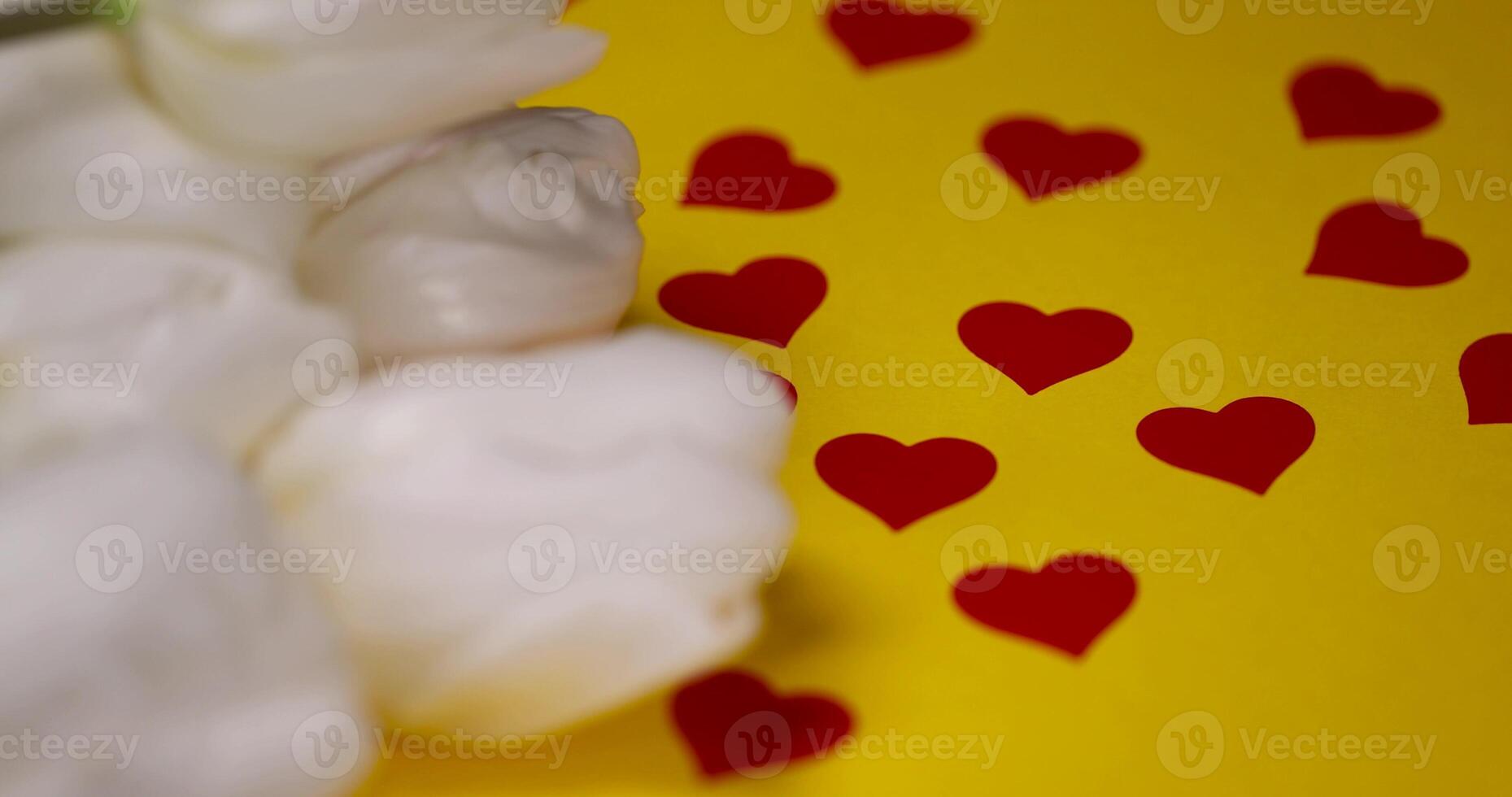 beautiful white tulips on yellow paper with red hearts photo