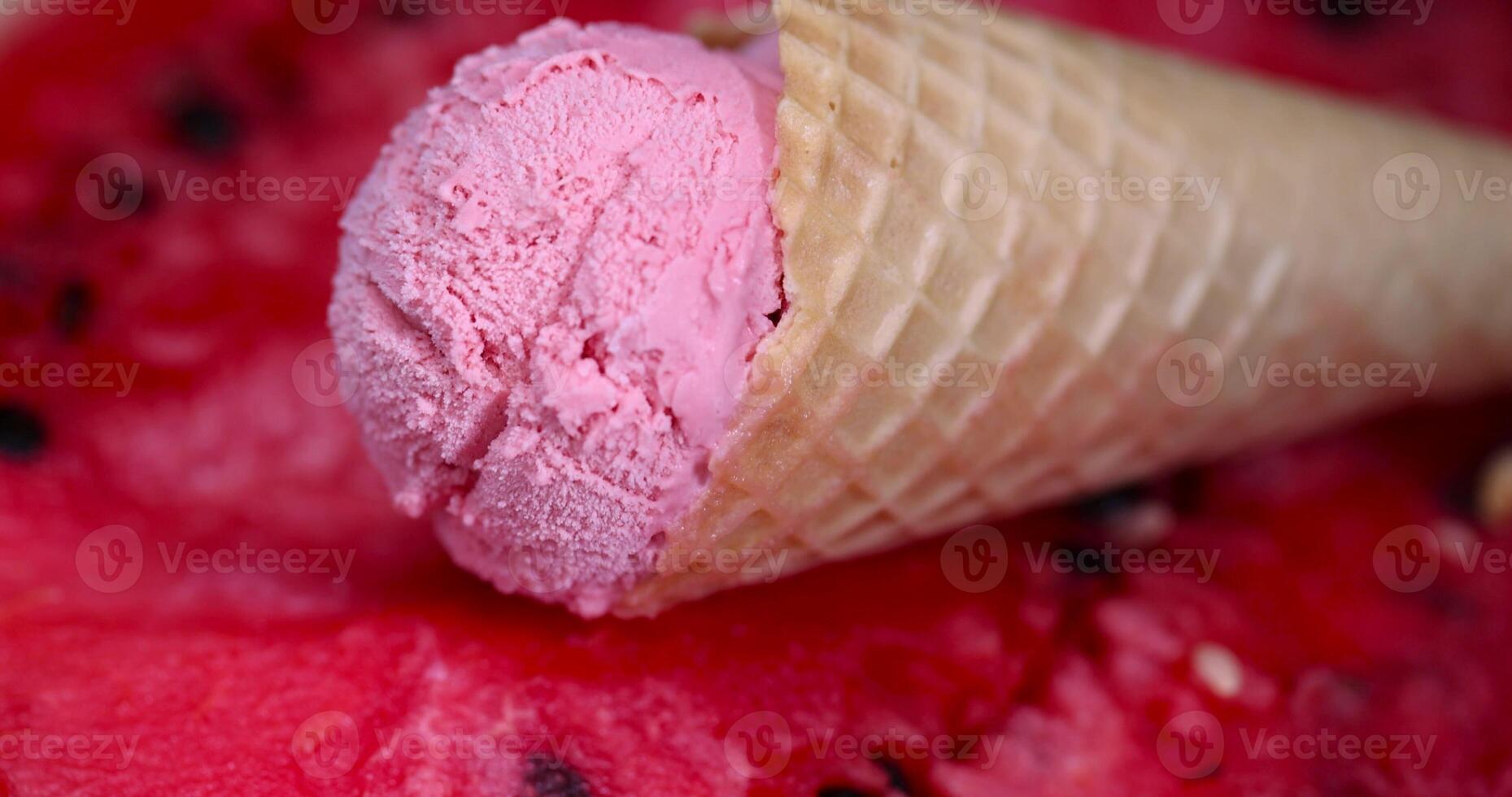 A pink ice cream cone with a watermelon in the middle photo