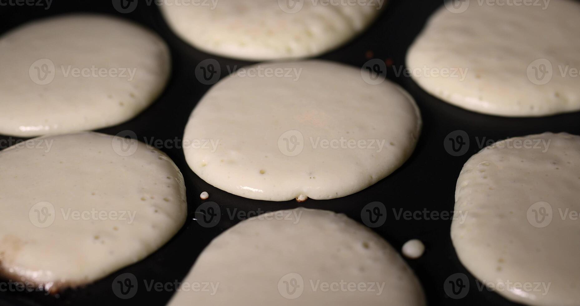 baking pancakes with butter in a frying pan close up, hot metal pan while cooking pancakes photo