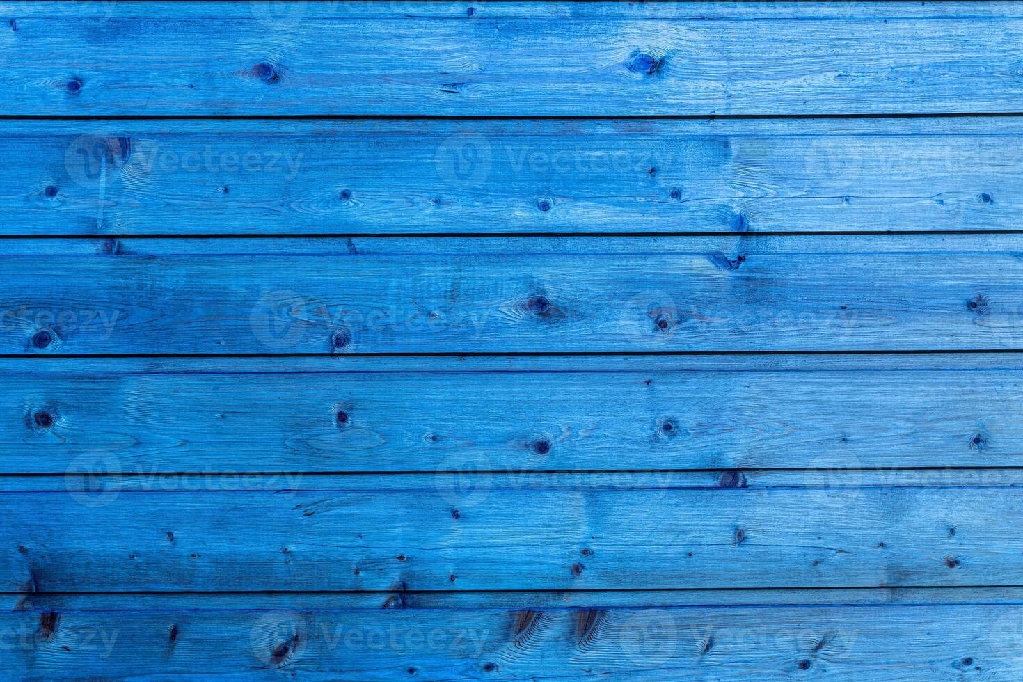 Horizontal planks of wood painted in bright blue with visible grain and knots in natural light. photo