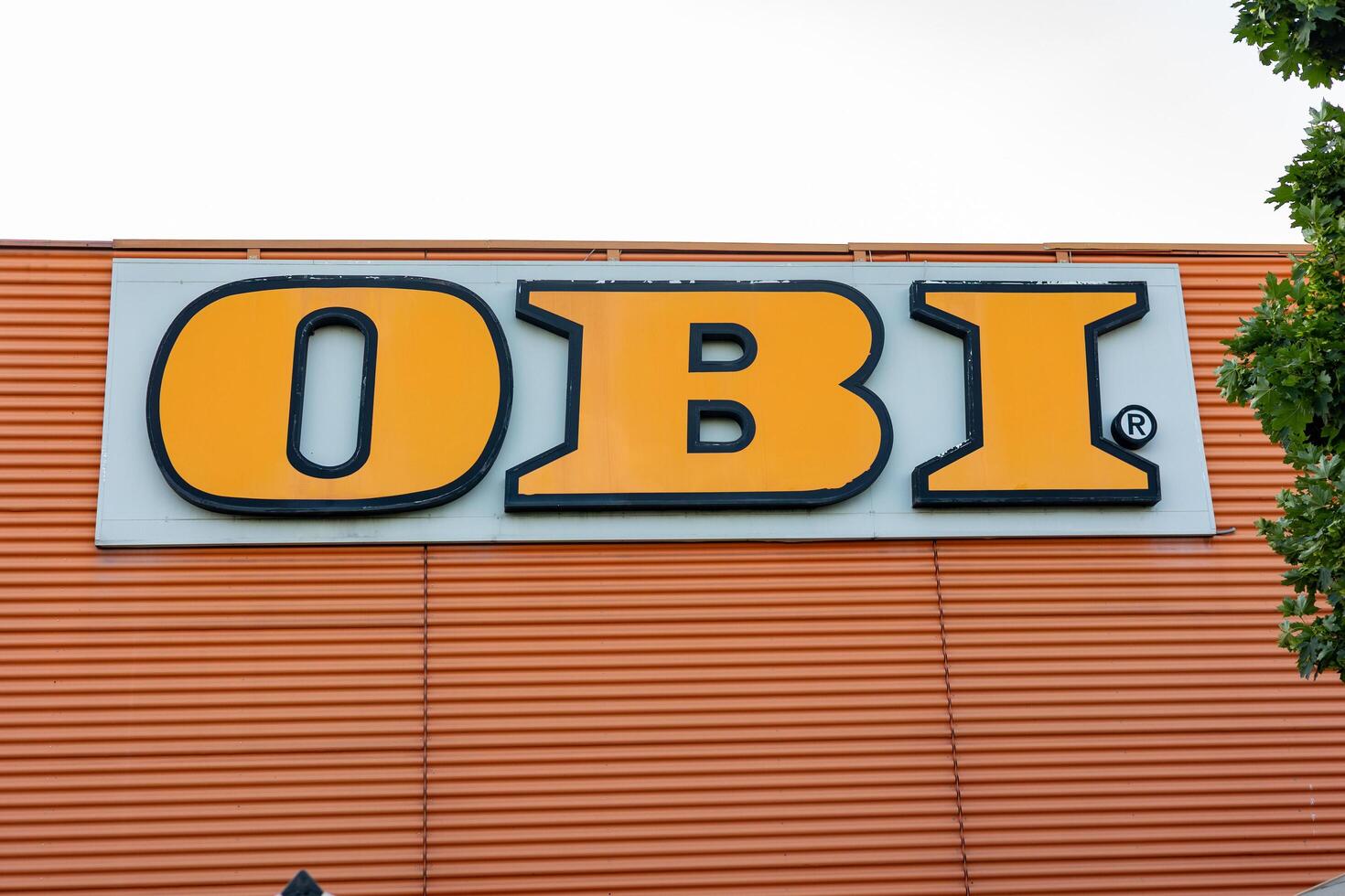 Piacenza, Italy - May 11, 2025 Logo of a popular european home improvement OBI retailer displayed prominently on a large warehouse, indicating a vast selection of diy and construction products photo