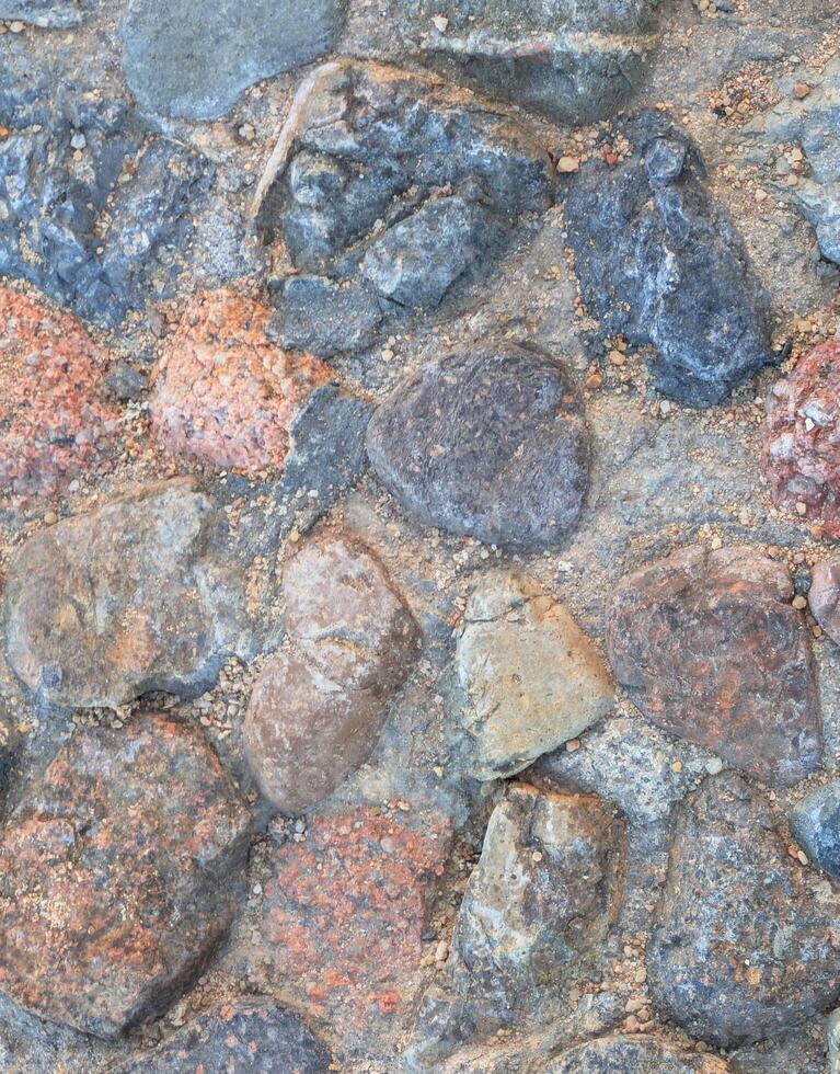 Old stone pavement vertical backgdrop, close up of large gray cobblestones. Perfect for abstract wall art, interior or exterior design, or nature inspired concepts photo