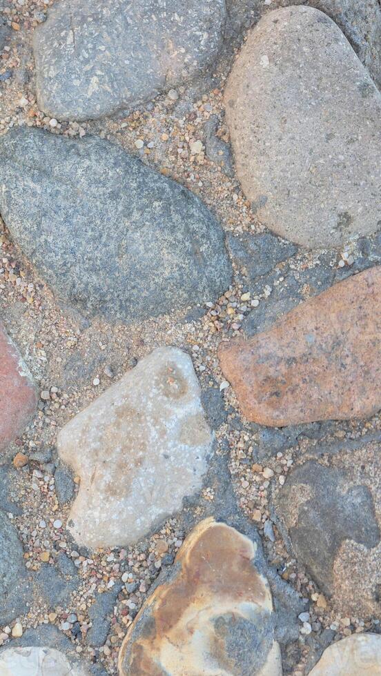 Rustic road stone vertical texture, detailed shot of organic gray cobblestones. Versatile backdrop for design projects, wall murals, or landscape themes photo