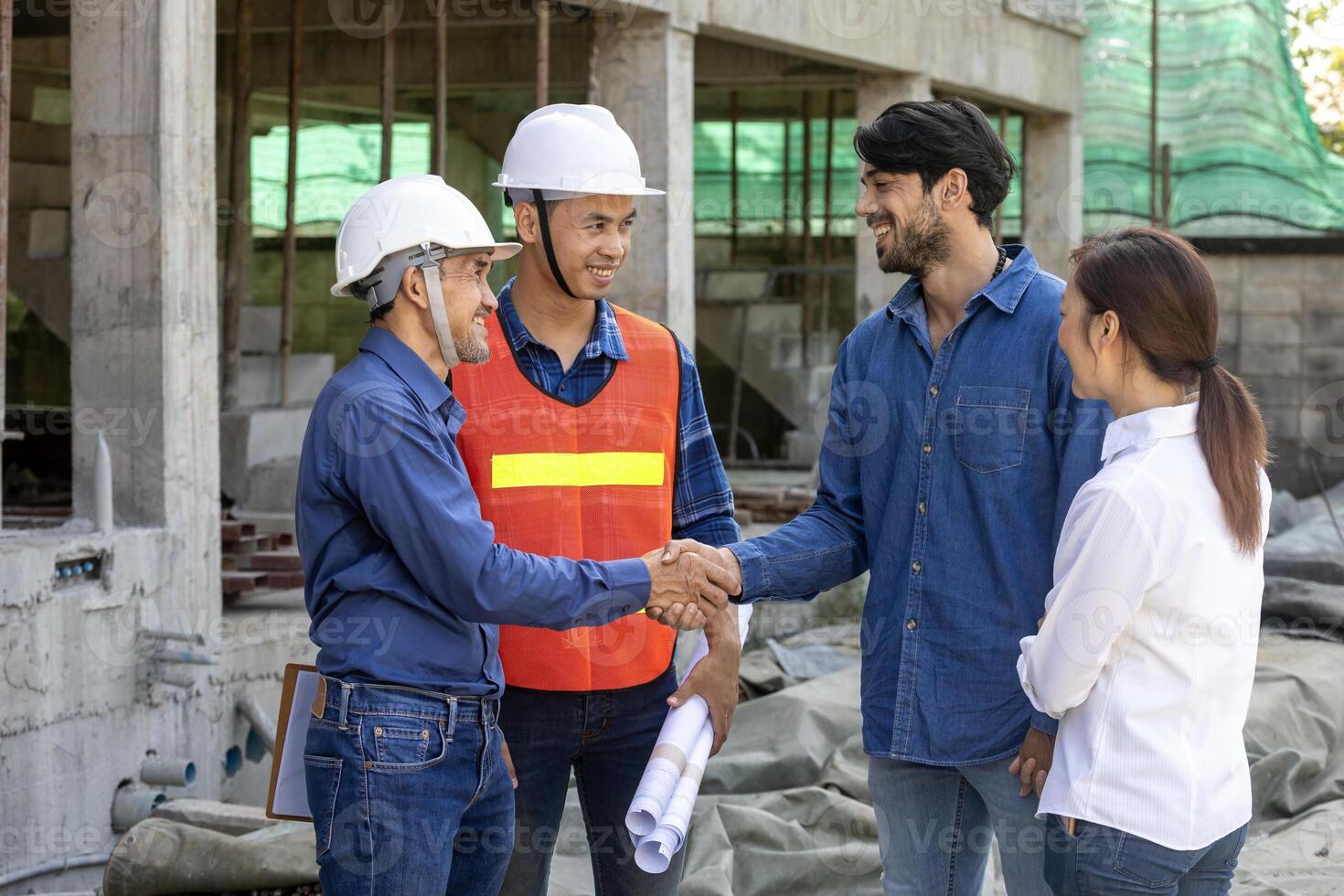 Newly wed couple is handshaking with engineering contractor at the under construction house to inspect building progress and quality control for home ownership and real estate development photo