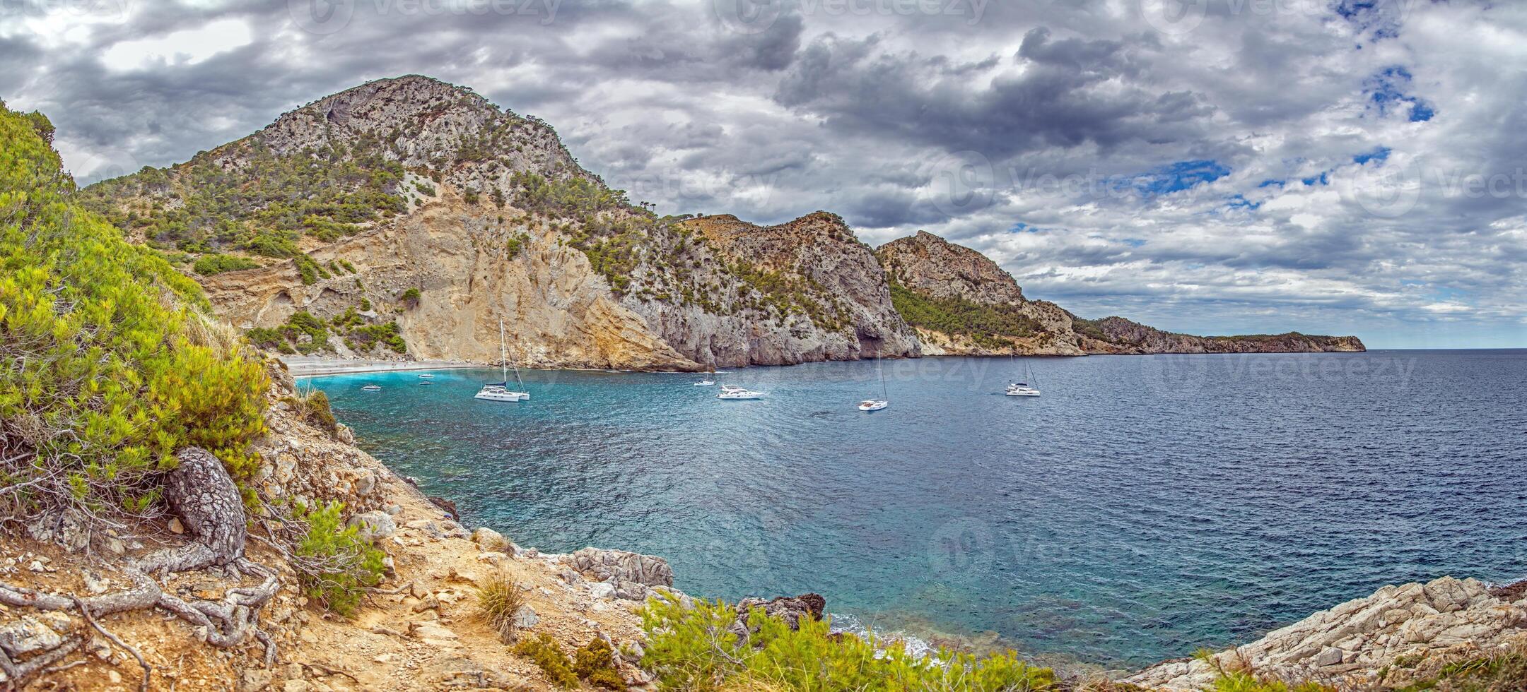 Cala San Vincenc bay with yachts and cliffs photo