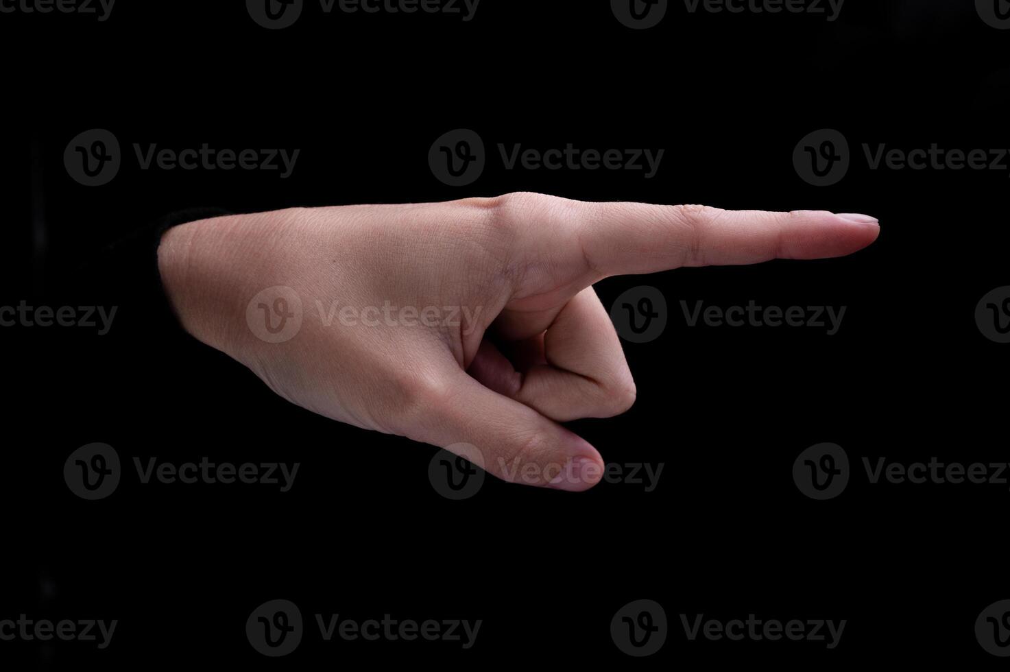 Female hand of caucasian woman pointing fingers to the right side on black background photo