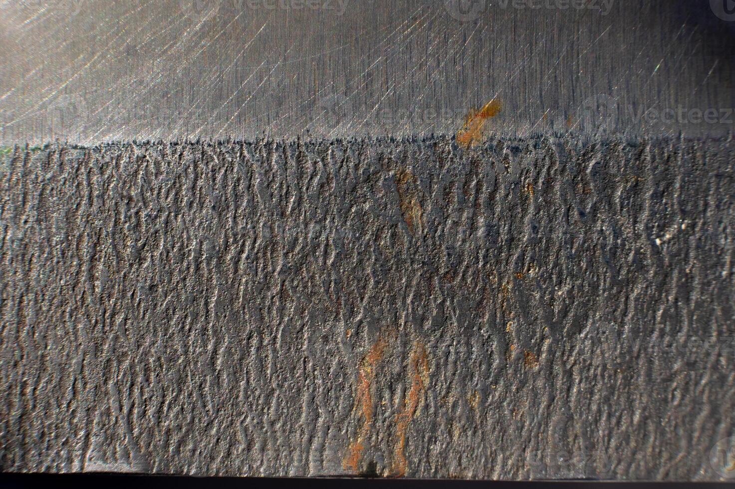 Close-up of the textured surface of a kitchen knife with rust stains. Macro shot of metal surfaces photo