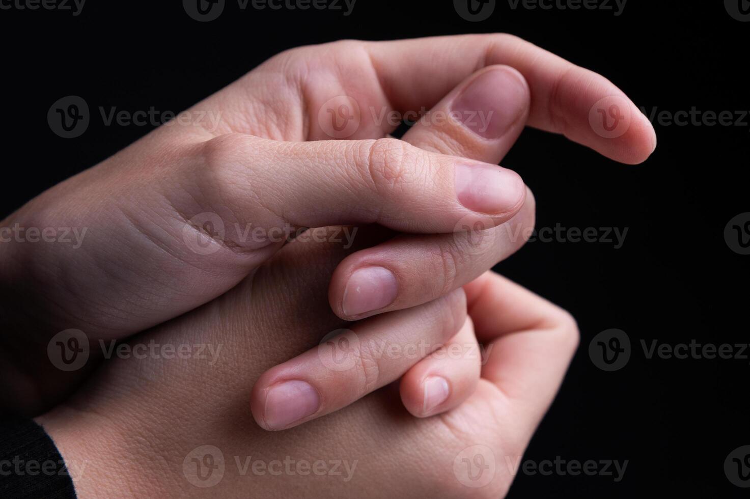 Close up of woman's hands intertwined together, delicate feminine hands with neat manicure. Support and touching herself photo