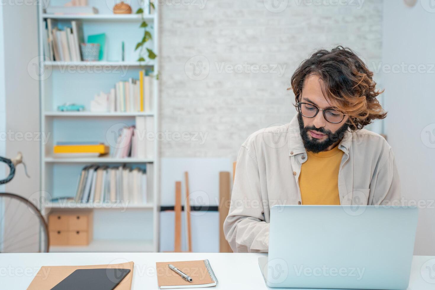 Man using laptop at home remote work in a small business with copy space. photo