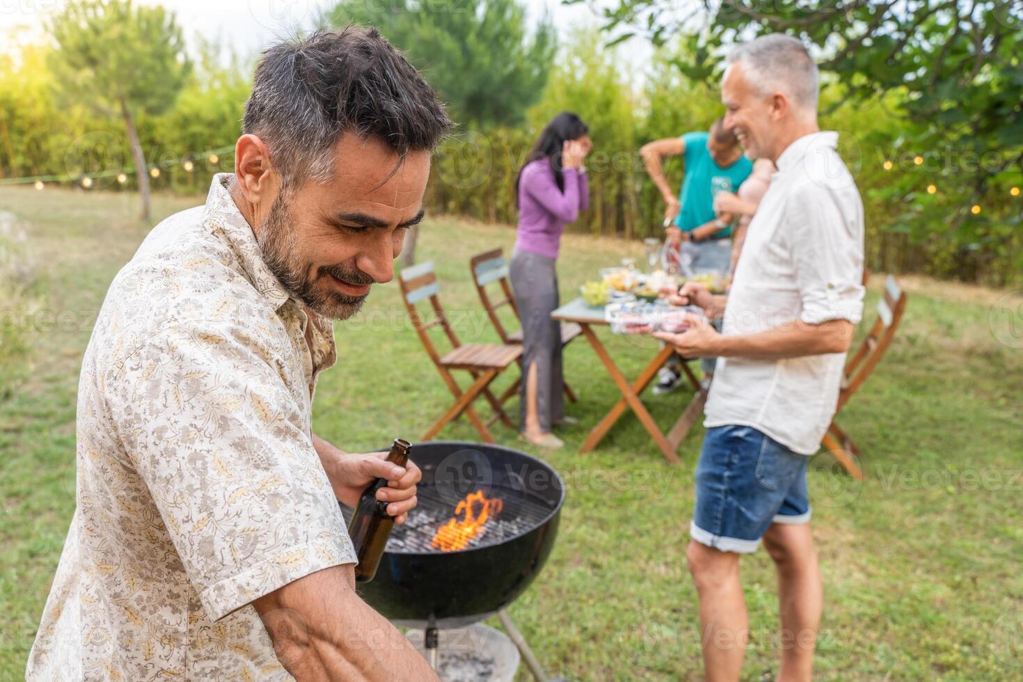 People around the barbecue smiling happy and laughing together. Joy concept. photo