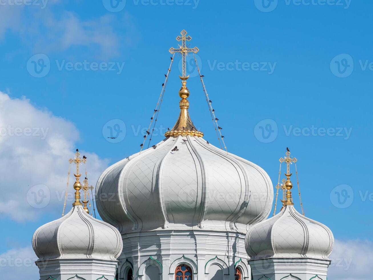 Golden crosses on white domes. photo