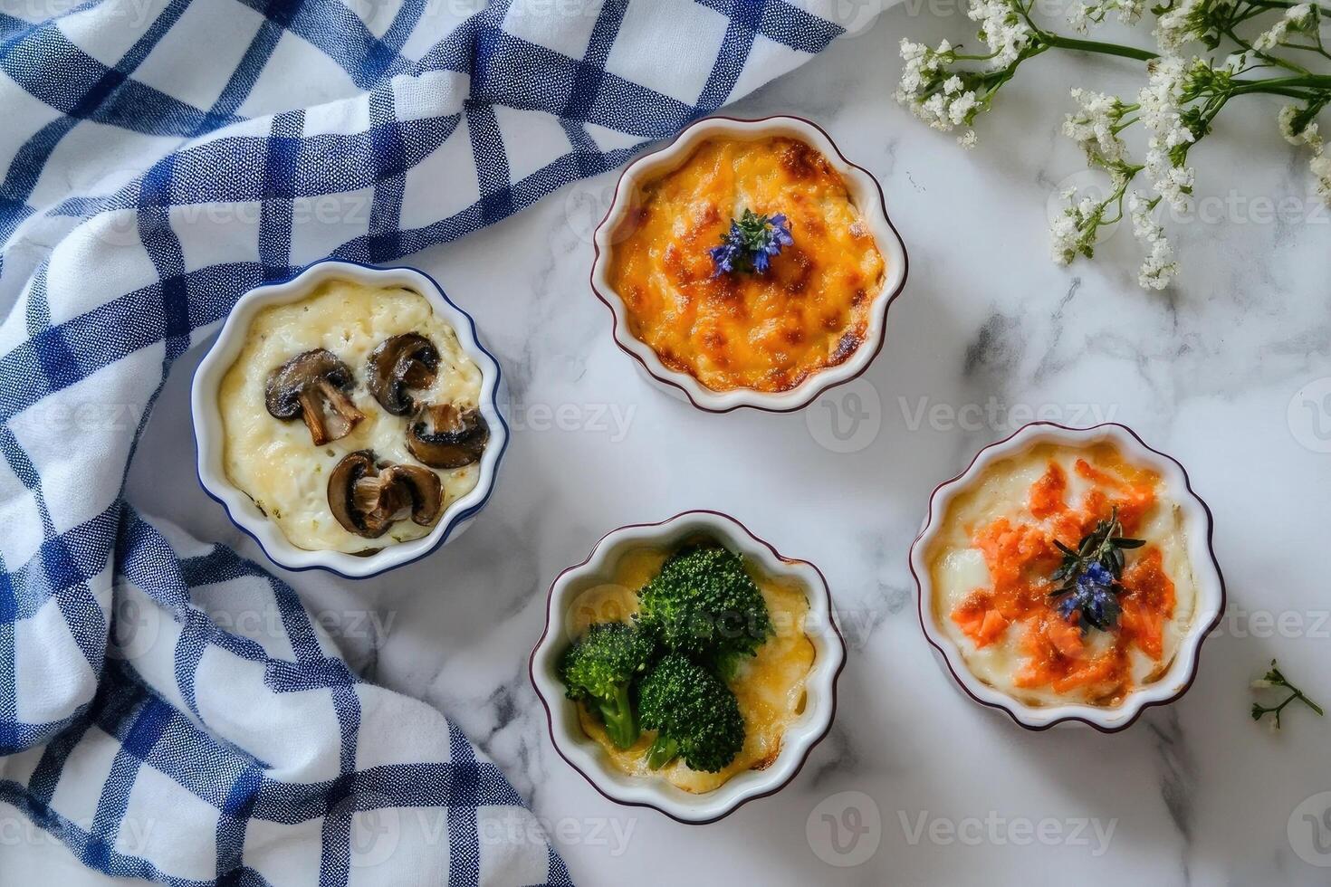 Mini casseroles featuring broccoli with cheddar, mushrooms with sun-dried tomatoes, and egg with salmon served on a marble countertop photo