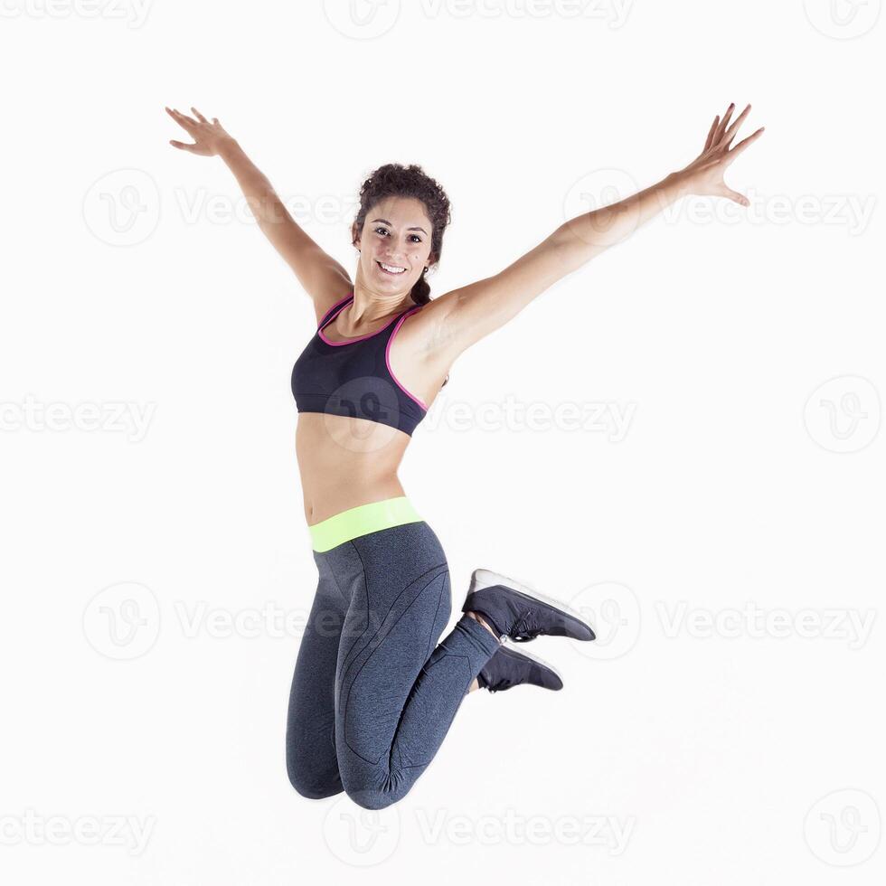 young professional athlete in sportswear having fun jumping on white background photo