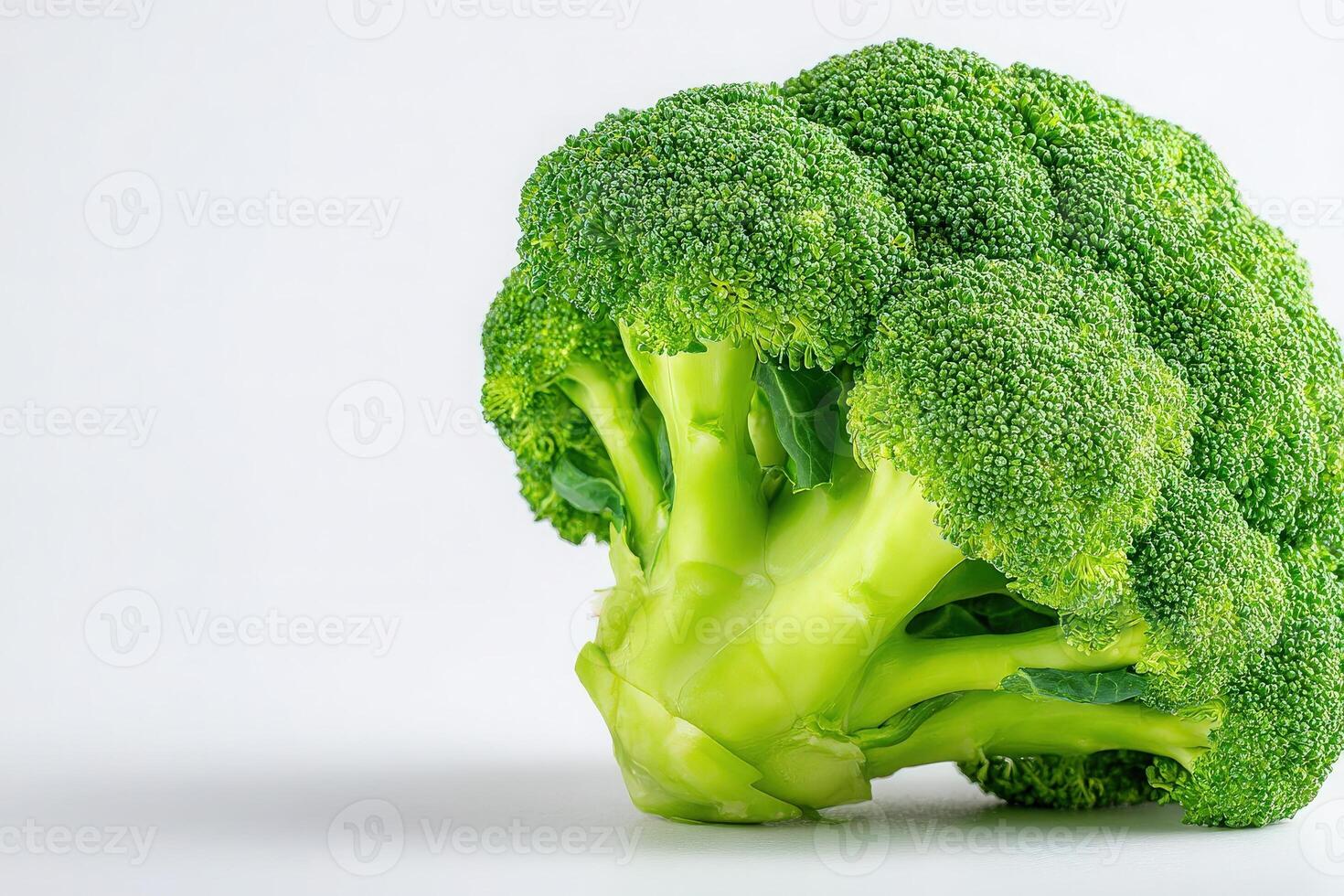 Close-up view of fresh broccoli with bright green florets and crisp stems. This nutritious vegetable stands against a plain background, emphasizing its rich color and freshness. photo