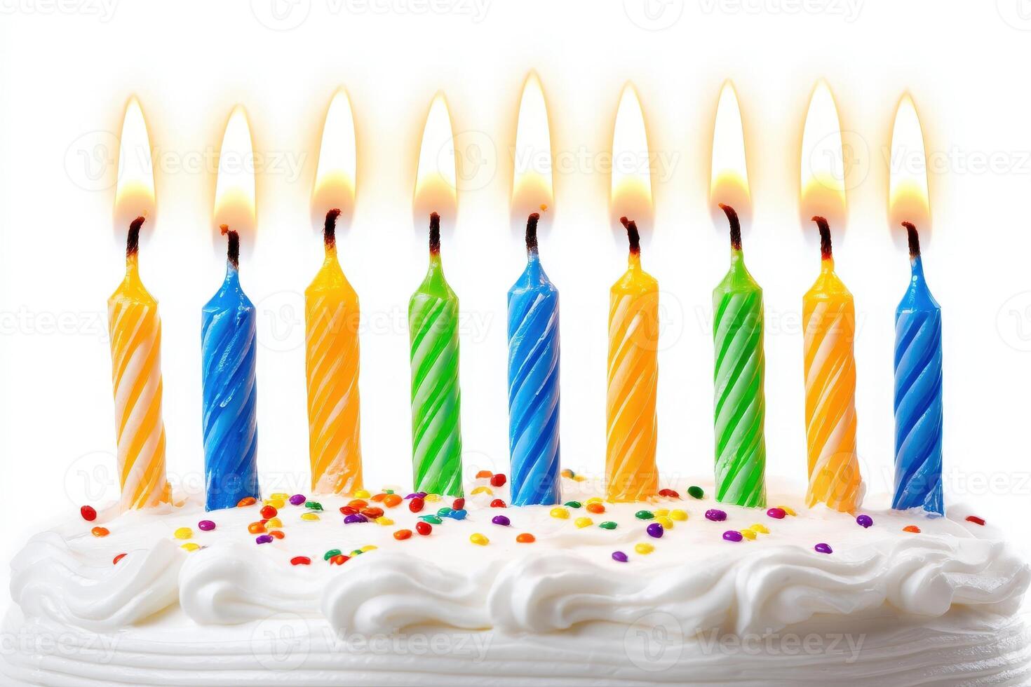 A white frosted cake is topped with ten vibrant candles of blue, orange, and green colors, all lit and ready for a birthday celebration surrounded by colorful sprinkles. photo
