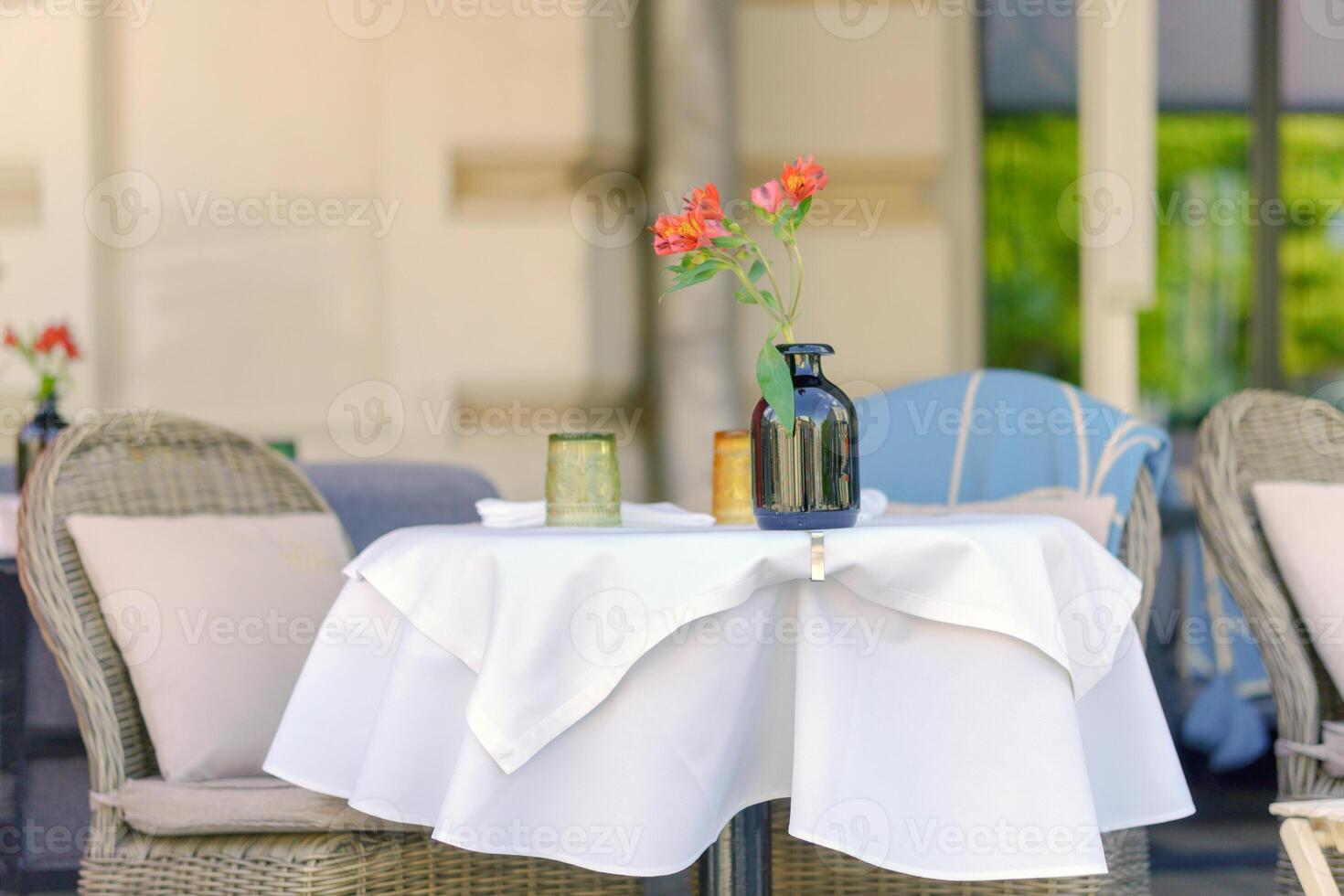 Delicate flowers on a table in an outdoor cafe. Restaurant on the street in the city. photo