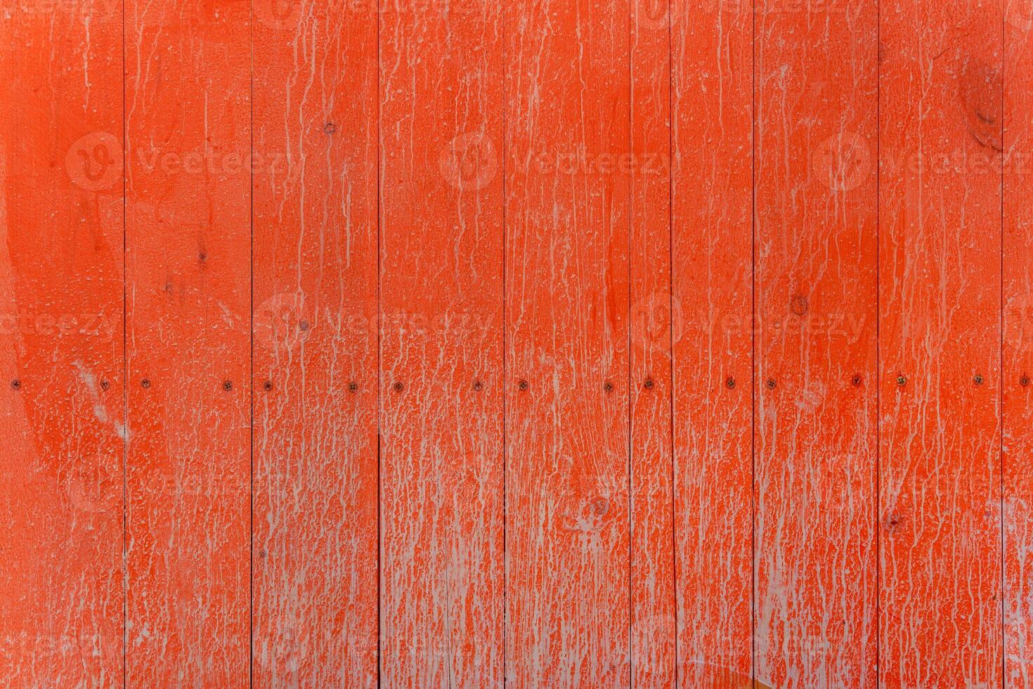 A fence of dirty red boards covered with stains and smudges. Natural decorative background. photo