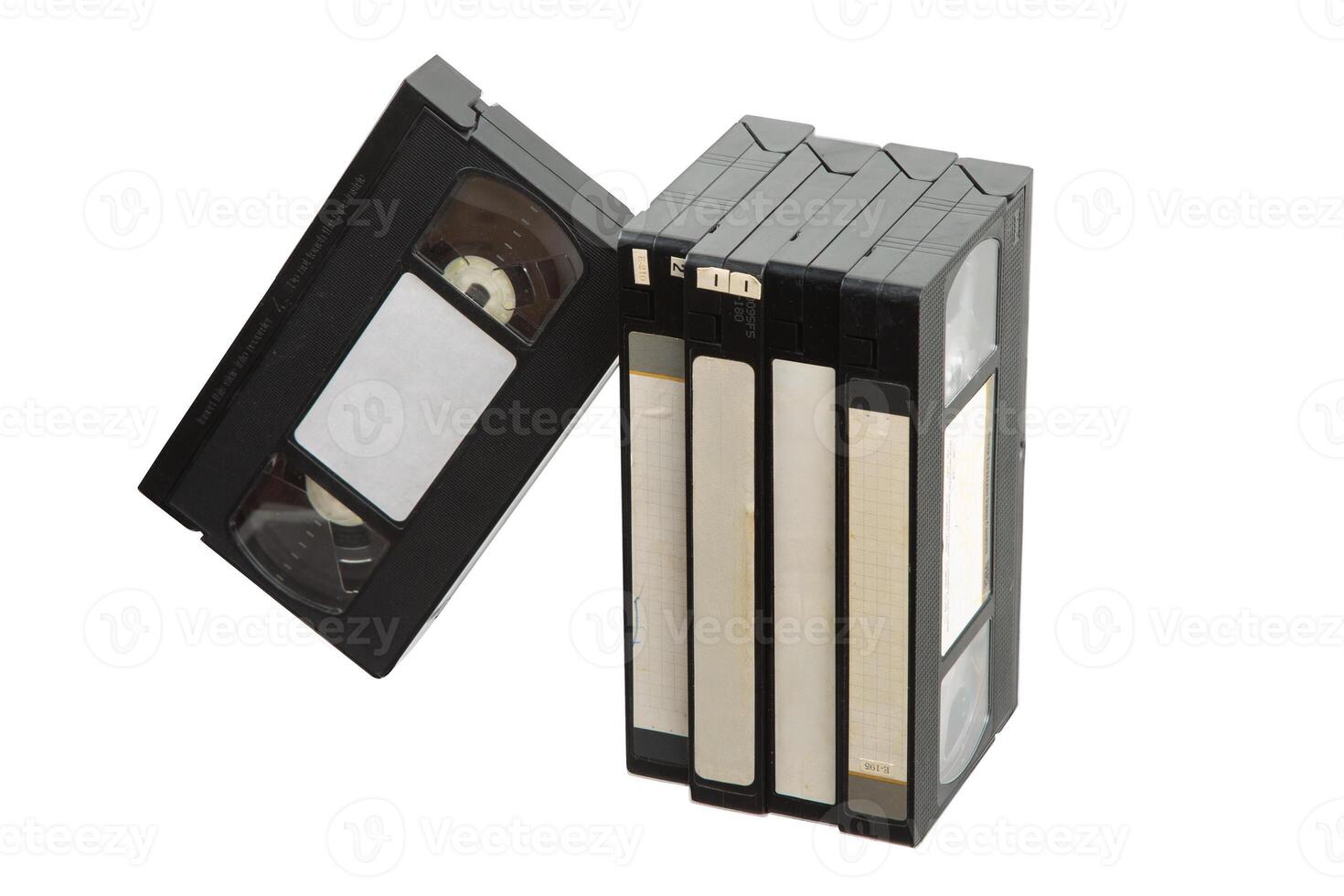 Group of vintage VHS tapes with blank labels, standing and leaning on white back photo