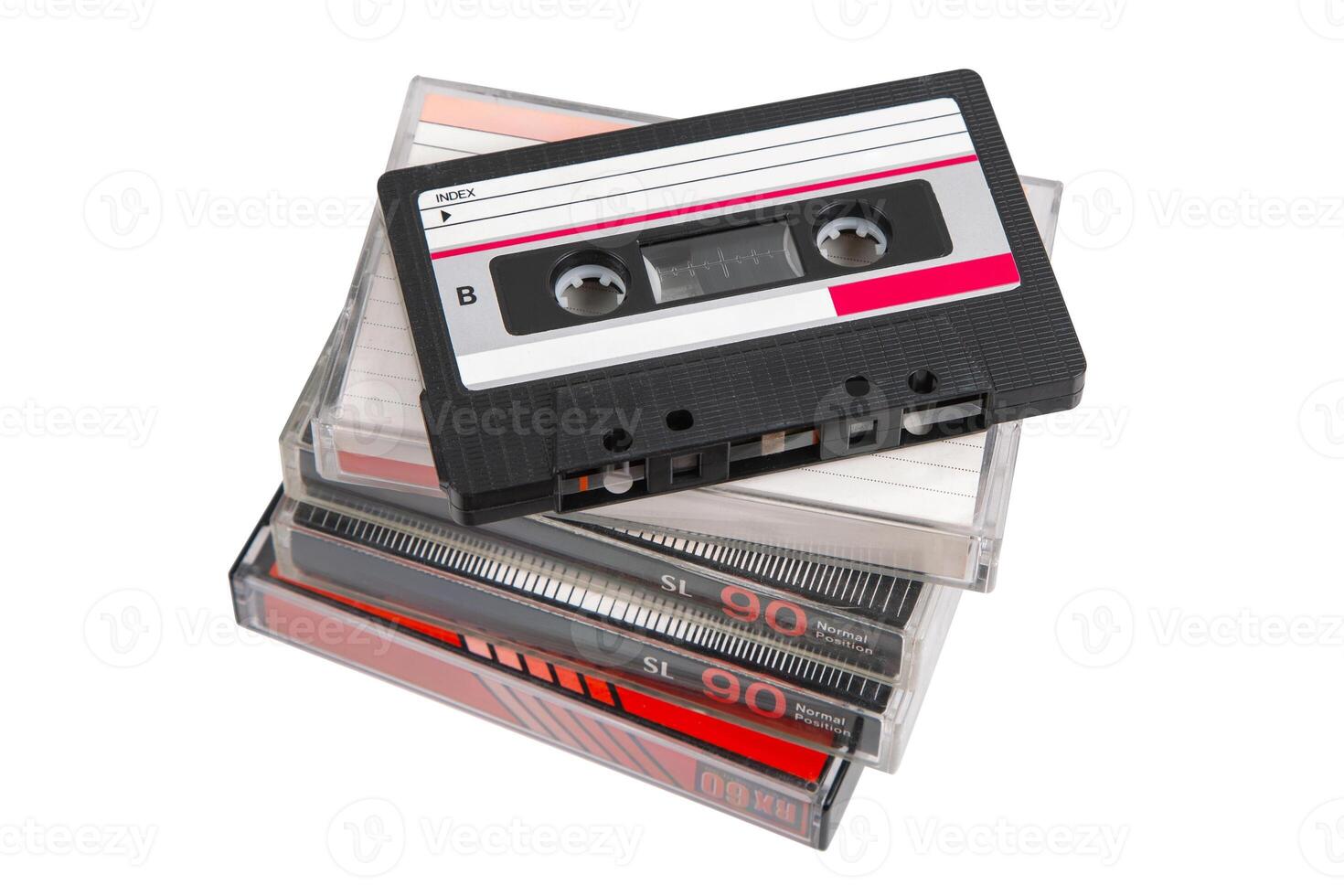 Stack of retro audio cassettes with one on top, angled and uncovered, on white back photo