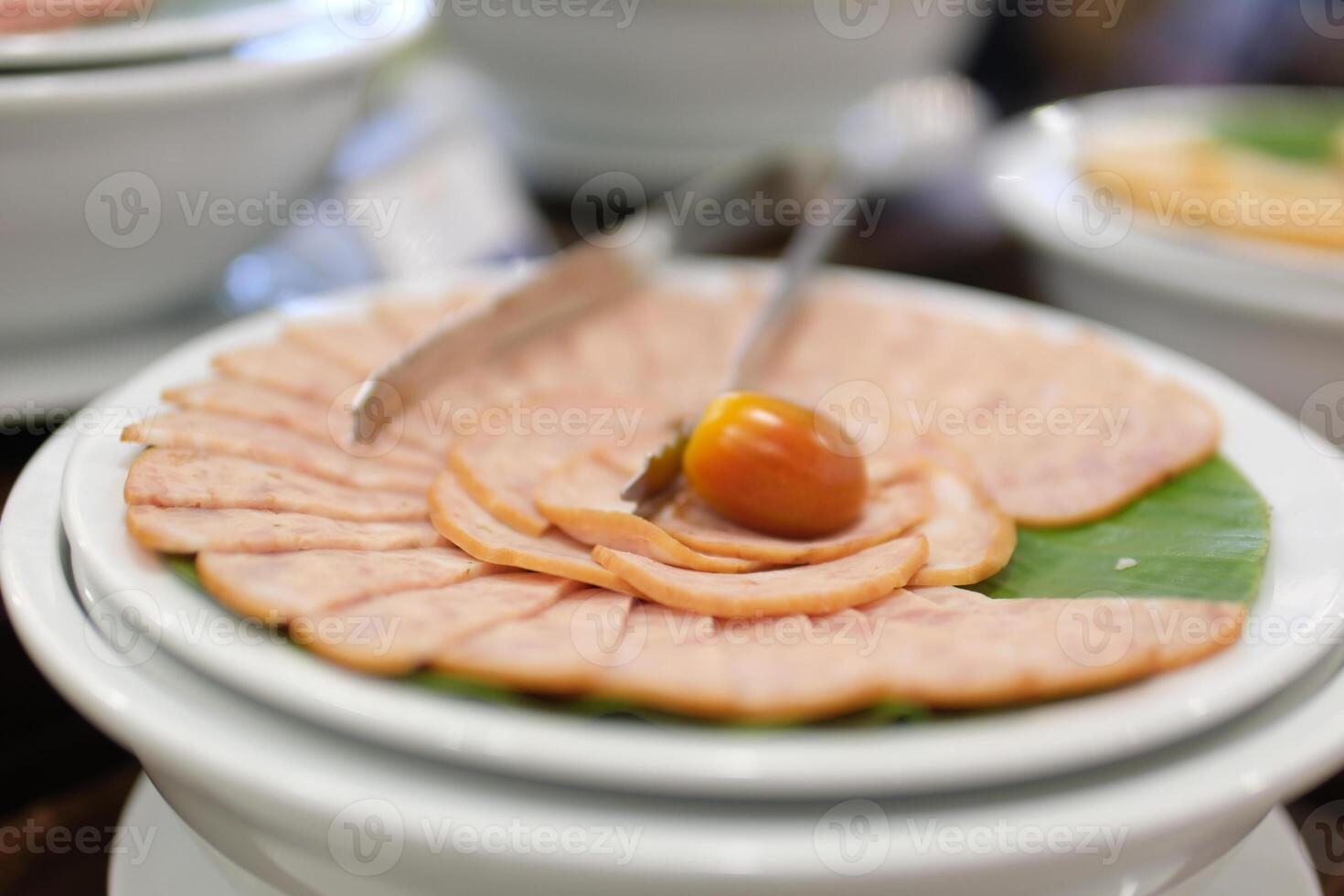 Ham slices tomato. meat delicacy with cherry tomato on a light background. turkey ham slices with parsley. cold appetizer on a white tablecloth. treat close-up. photo