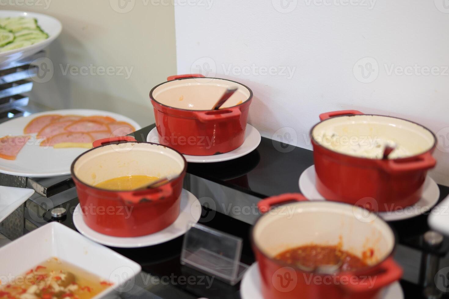 sauces in small red pots serving various toppings before meals at buffet photo