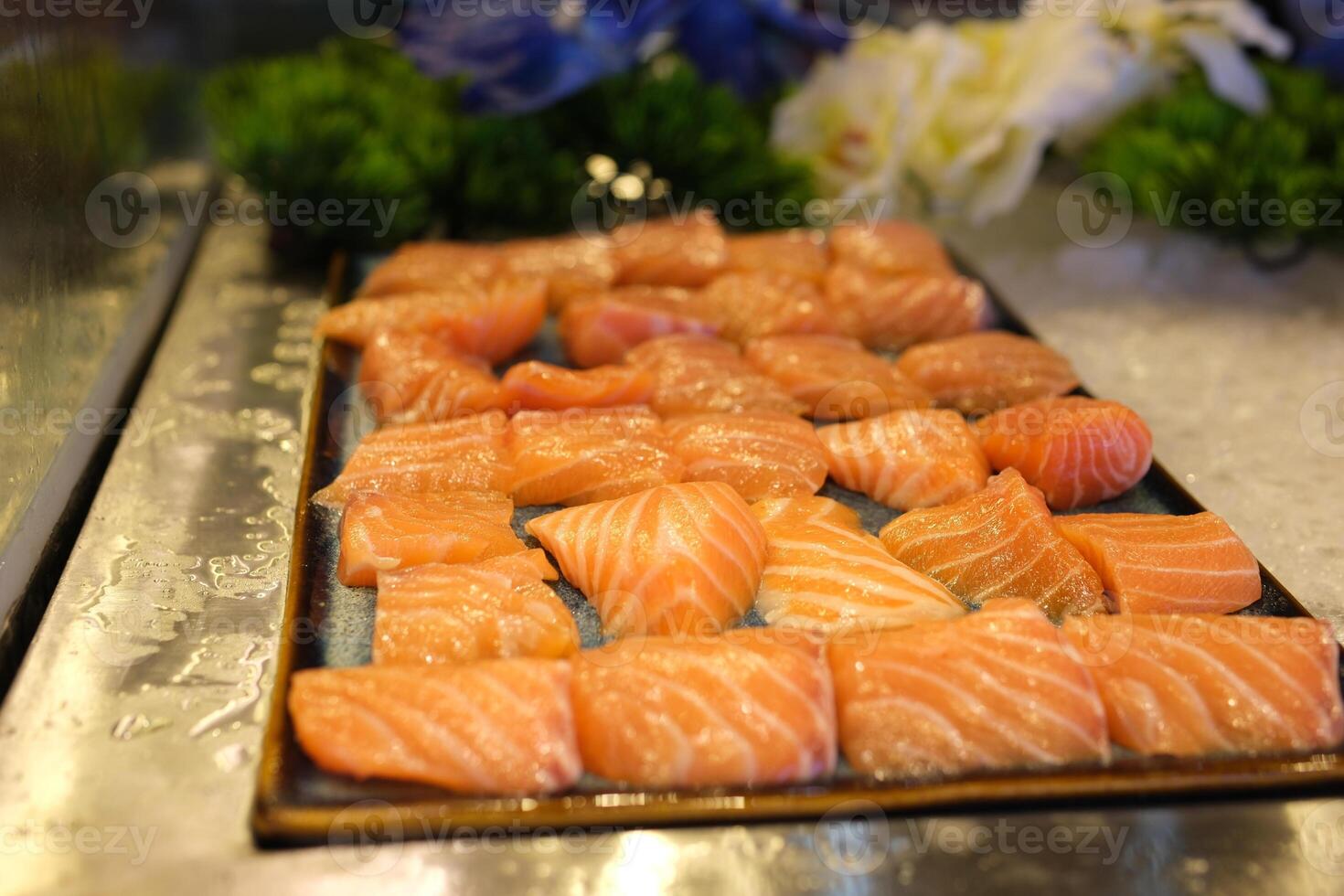 Traditional Norwegian fresh salmon in slices with lemon slices served as close-up on a Nordic design tray with text space photo
