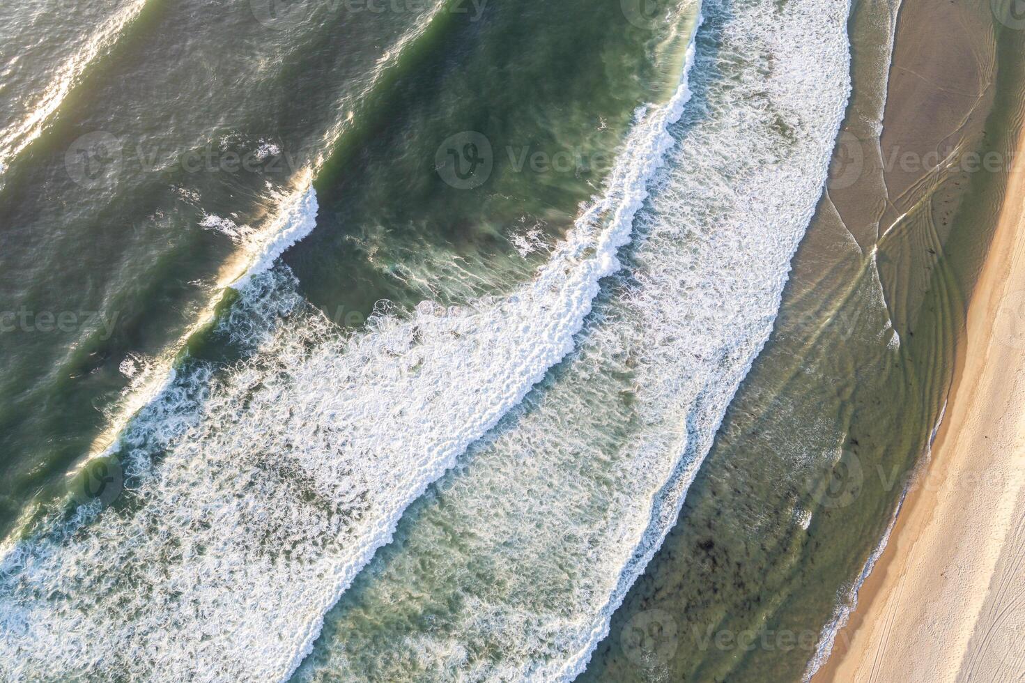 beach and ocean landscape from above with breaking waves aerial perspective of the sea and beach interface photo
