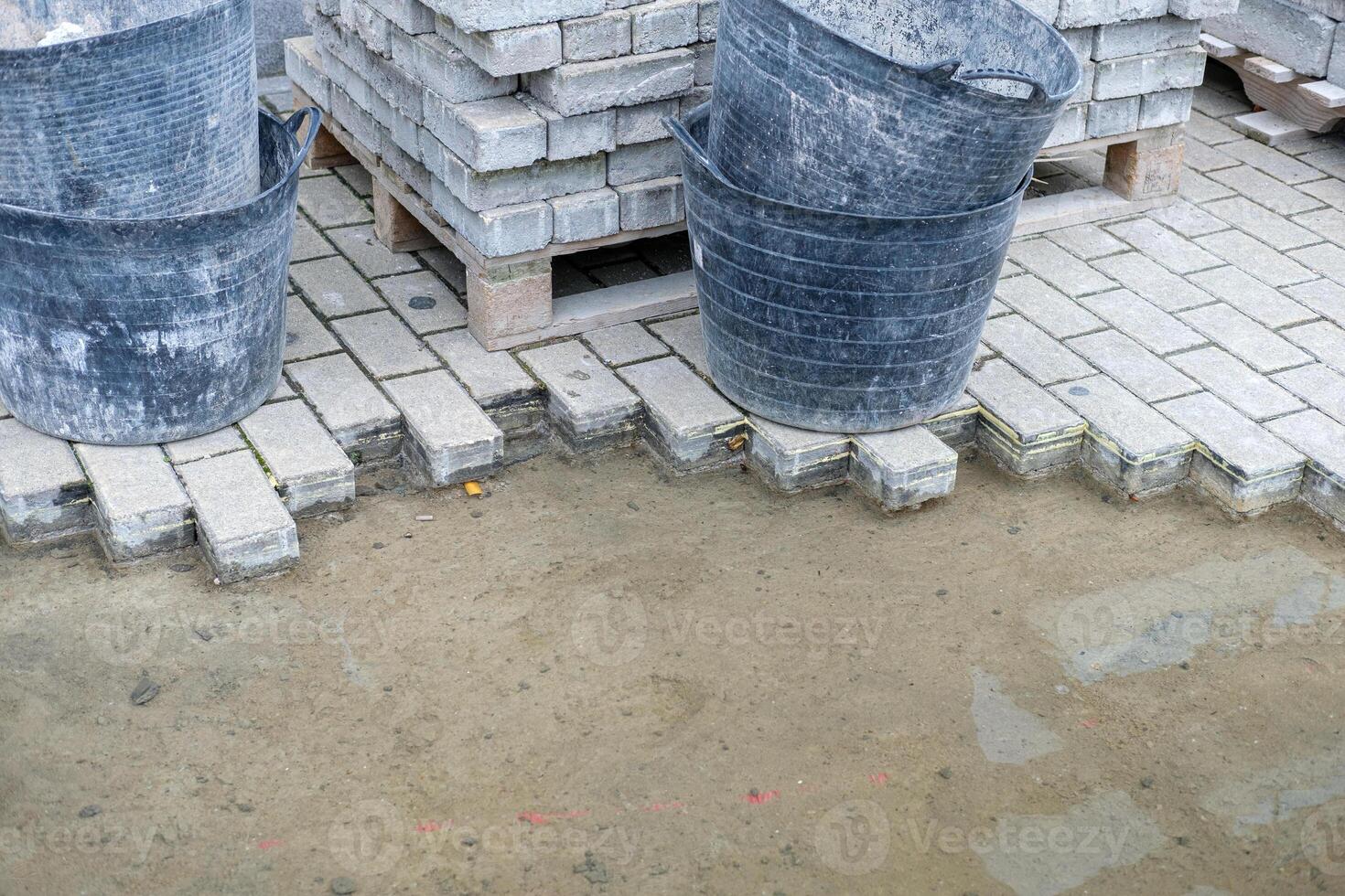 paver installation in progress with flexible work tubs preparing ground for garden paver pathway construction photo