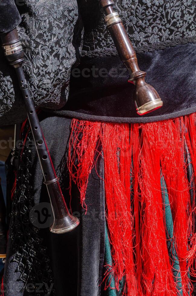 part of a bagpipe of a woman dressed in the traditional Galician style to play folk music. photo