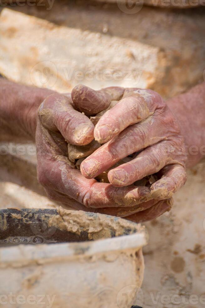 hands covered in clay working on ceramics, creative process of handmade pottery art photo