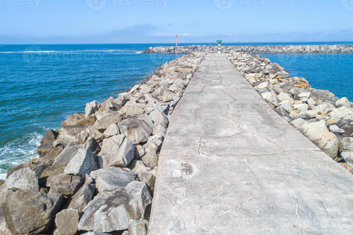 coastal barrier long concrete path on a rocky sea defense photo