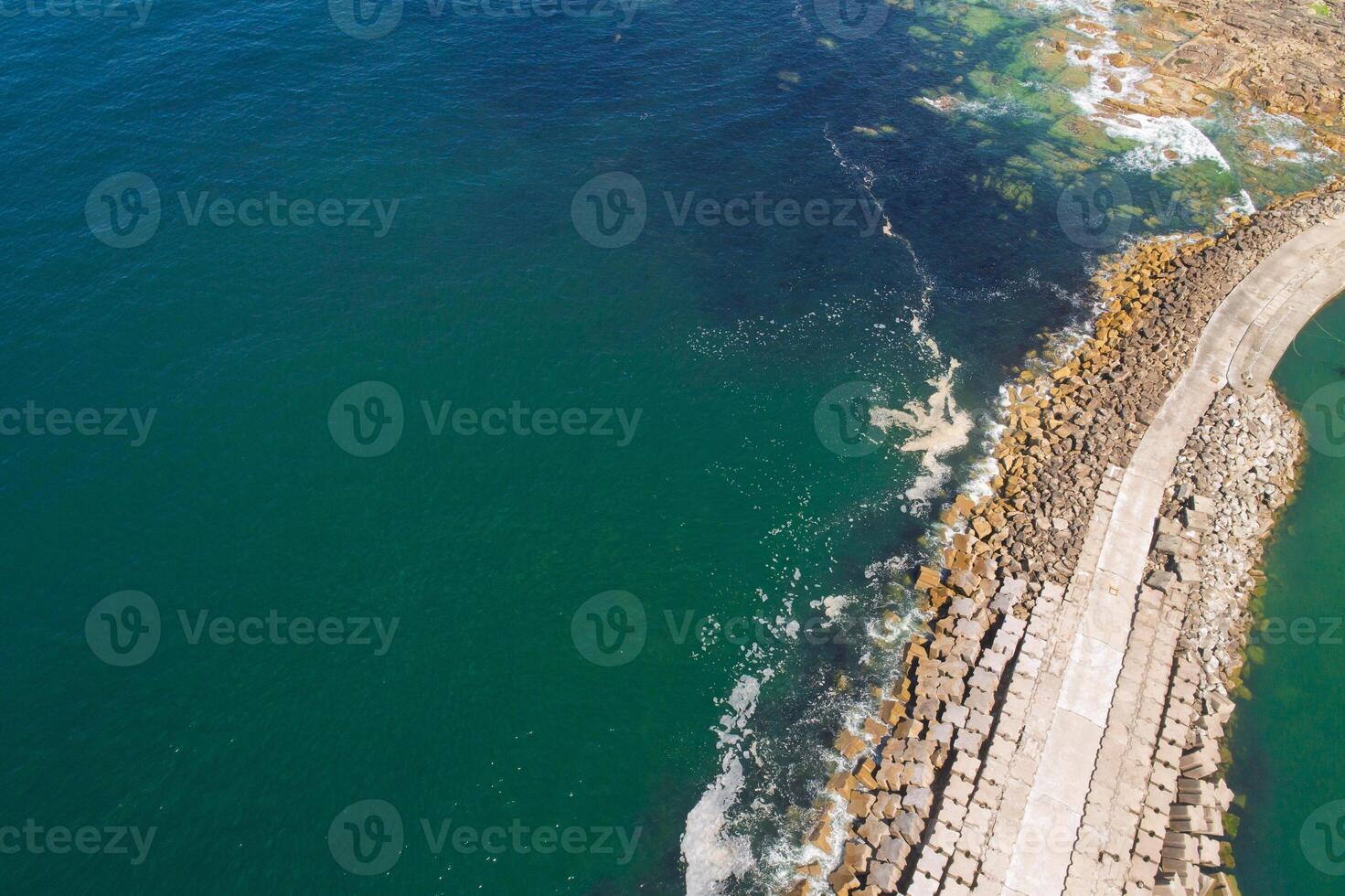 safe harbor top down view drone photography of a strategic breakwater with a beacon lighthouse photo