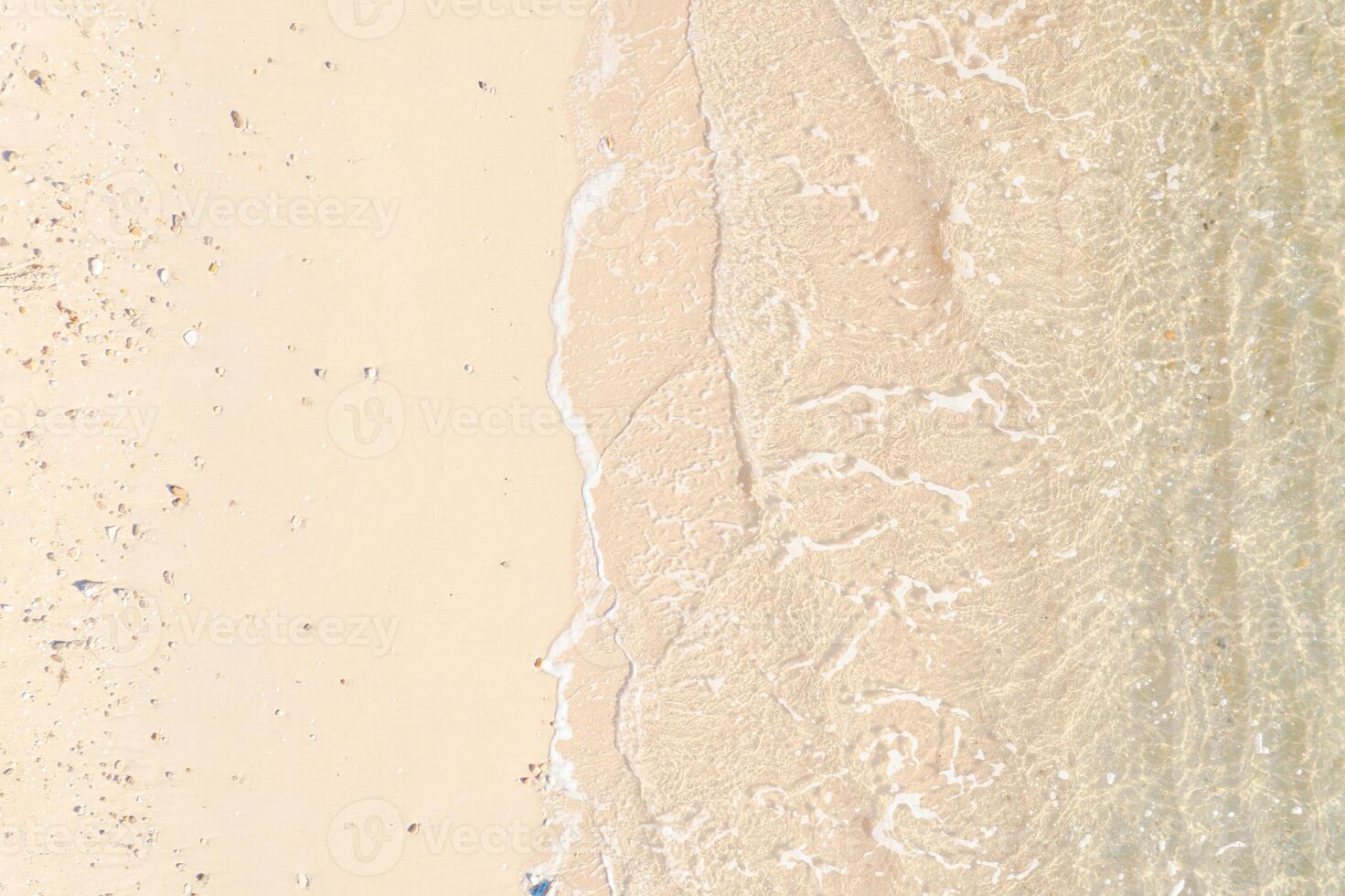 Aerial top view of beautiful tropical white sand beach with wave foam and transparent sea, Summer vacation and Travel background copy space, Top down view from drone photo