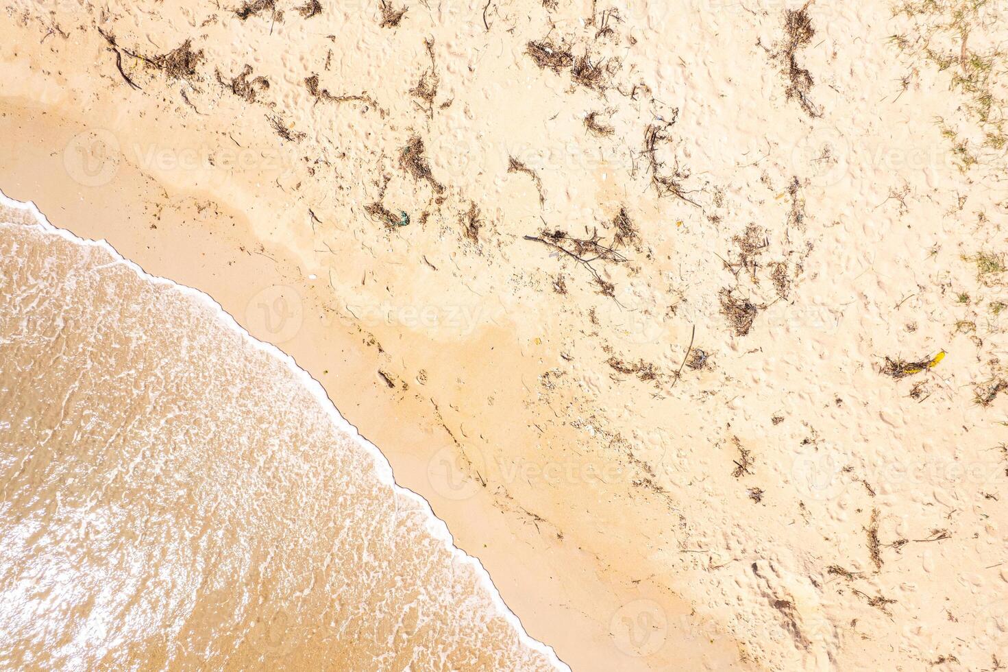 ocean waves washing over soft golden sand detail, summer concept aerial overhead drone view photo
