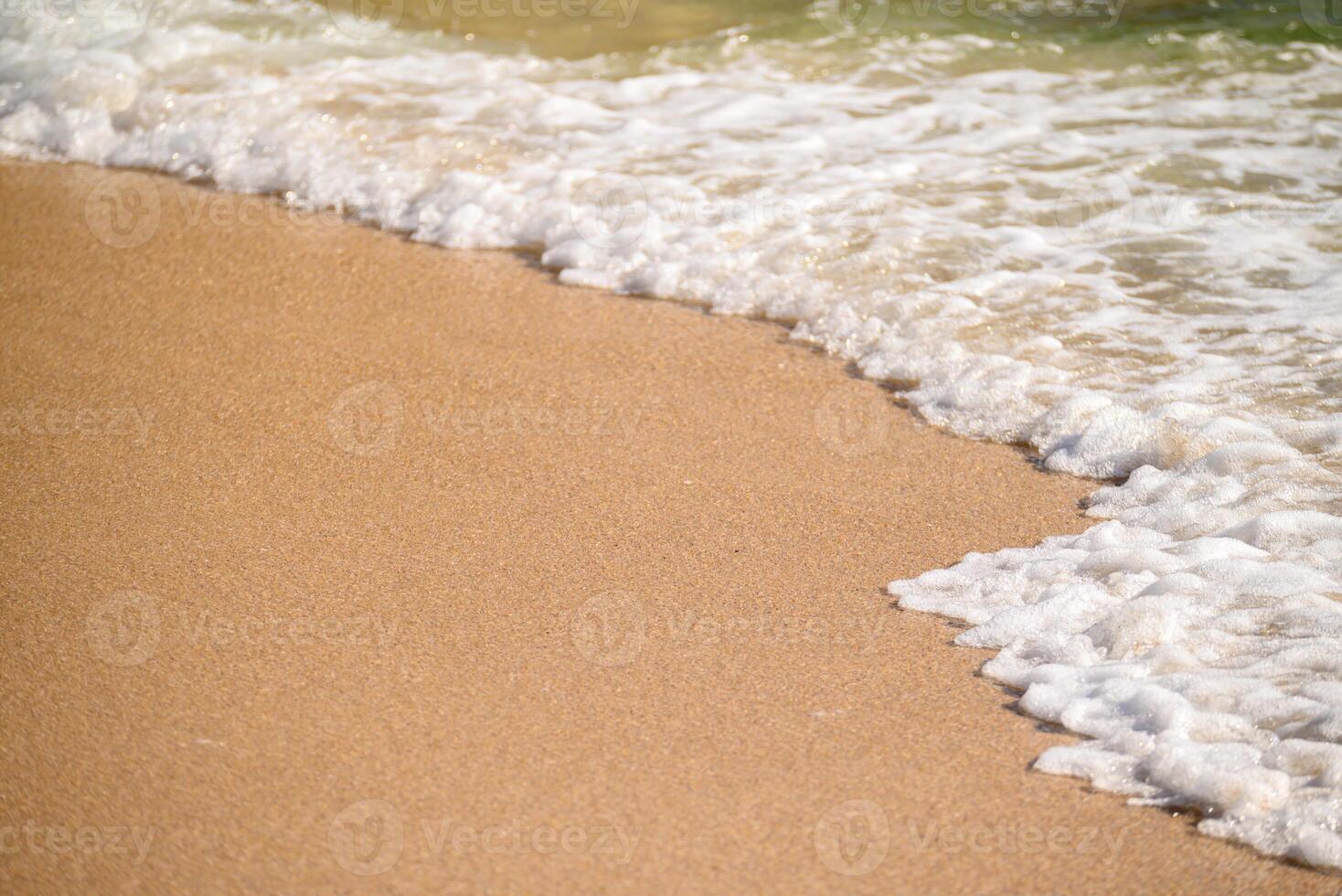 close up of golden sand and gentle sea foam on beach, summer concept background photo