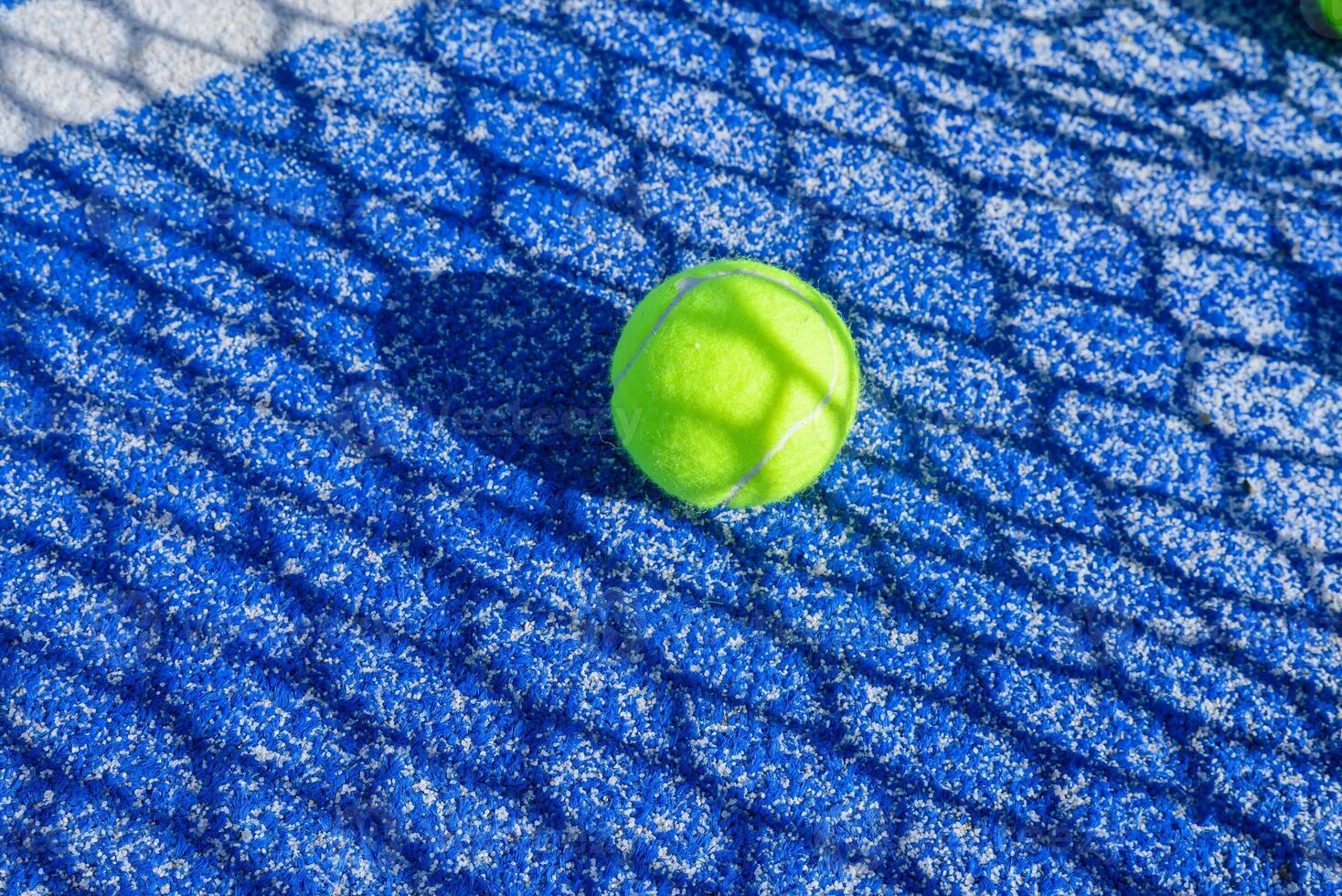 padel court showcasing the unique texture of the blue playing surface and bright balls photo