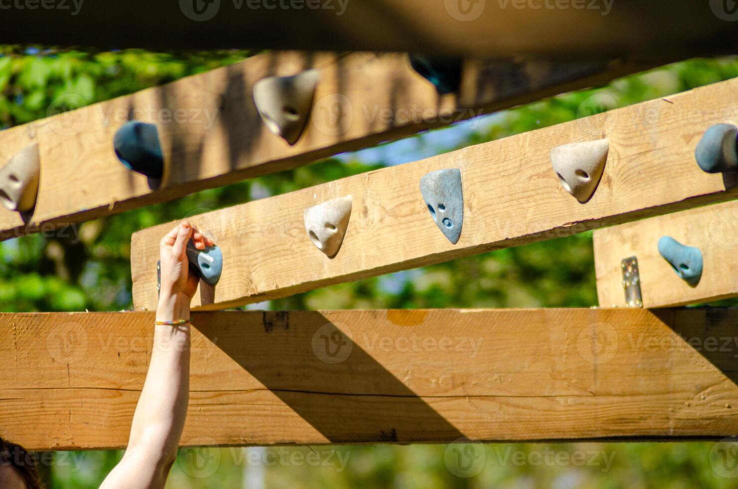 ocr athlete gripping wooden obstacle during endurance race photo