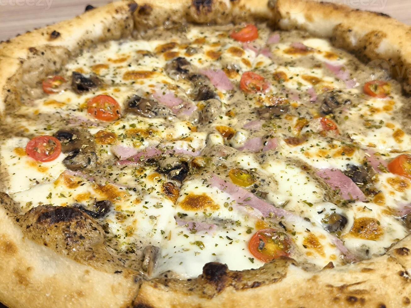 Delicious pizza with ham, bacon, mozzarella and tomato sauce photo