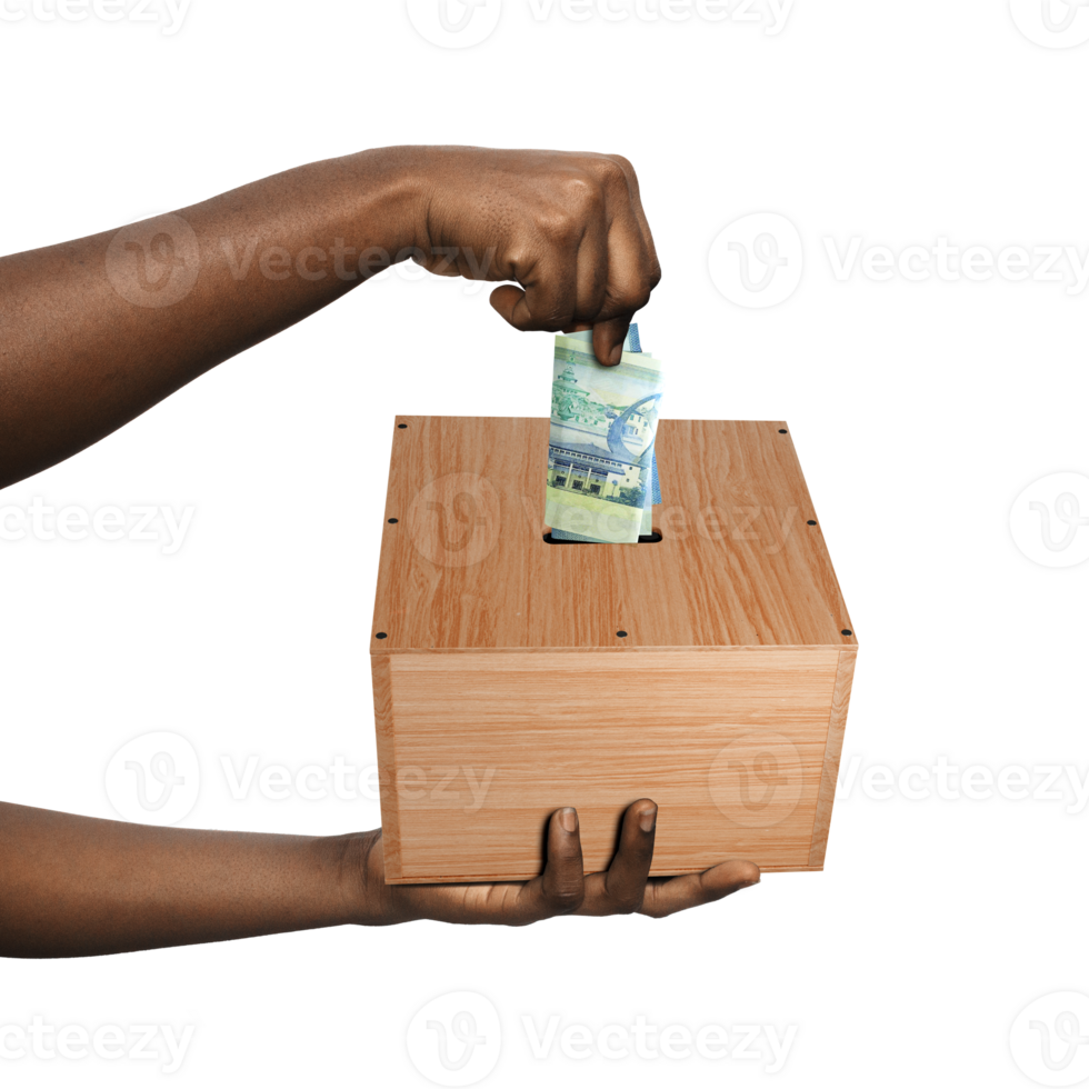Black African Hands holding and putting folded Ghanaian cedi note into wooden savings box over transparent background, personal future investment brown skin save money png