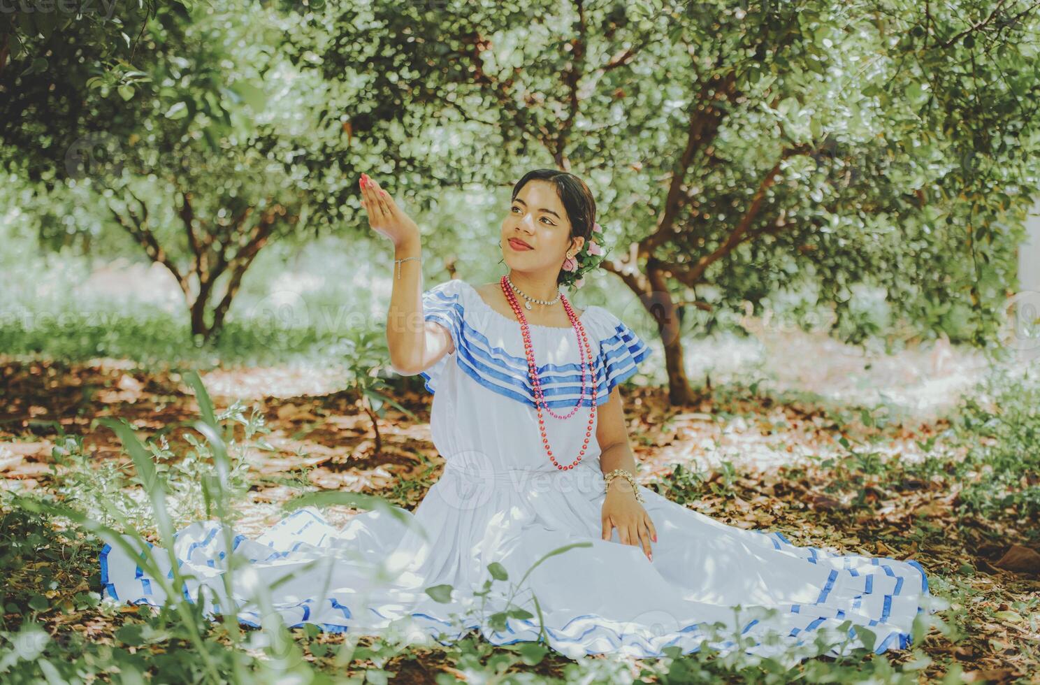 Portrait of girl in national folk costume sitting in the grass photo